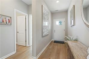 Bright foyer with wood-look flooring and modern decor in The Aurora A floor plan at Links Crossing, Auburn, Alabama.