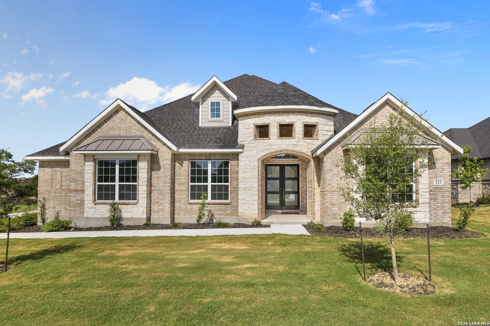 Stone and brick facade of The Summerlin B floor plan by Davidson Homes in Potranco Oaks, Castroville, Texas.