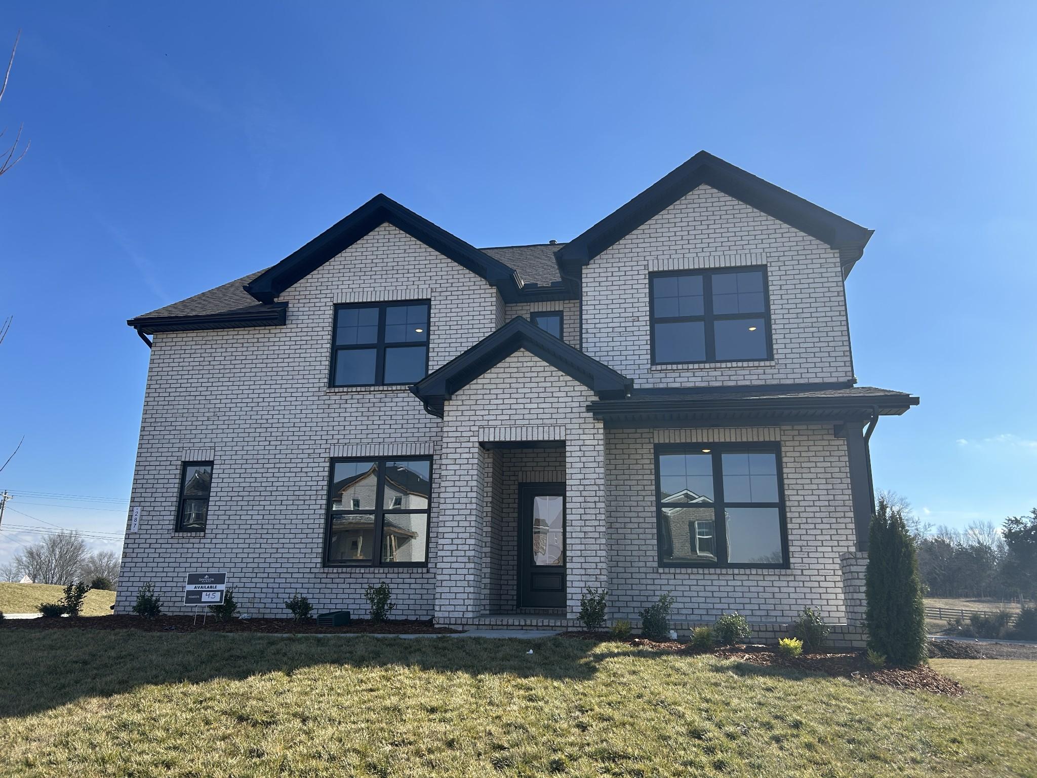 Two-story white brick home with black trim, gabled roof, and landscaped yard in Benders Cove, Mt. Juliet, Tennessee