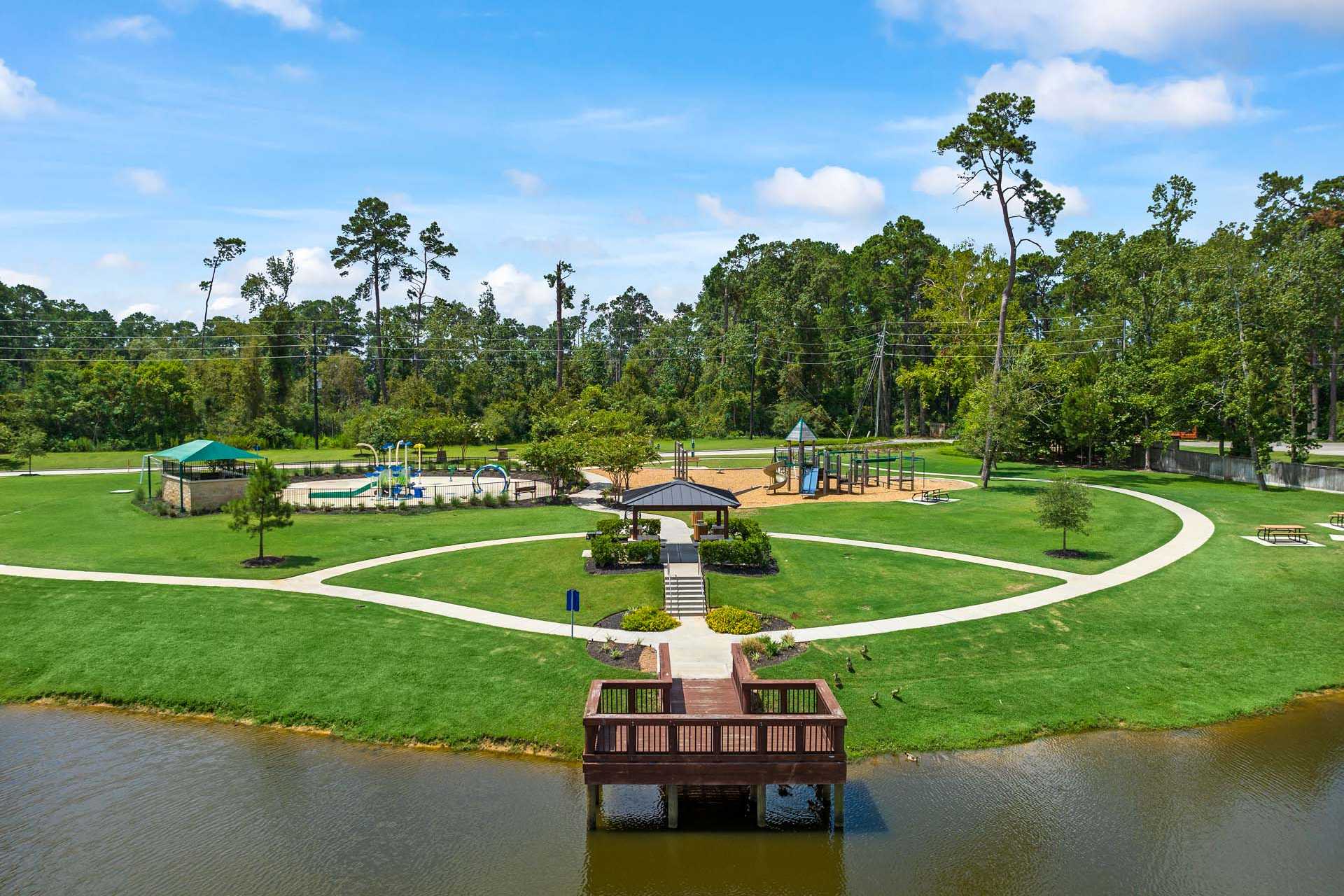 Playground with swings, slides, gazebo and wooden lake dock at Lakes at Black Oak in Magnolia, Texas