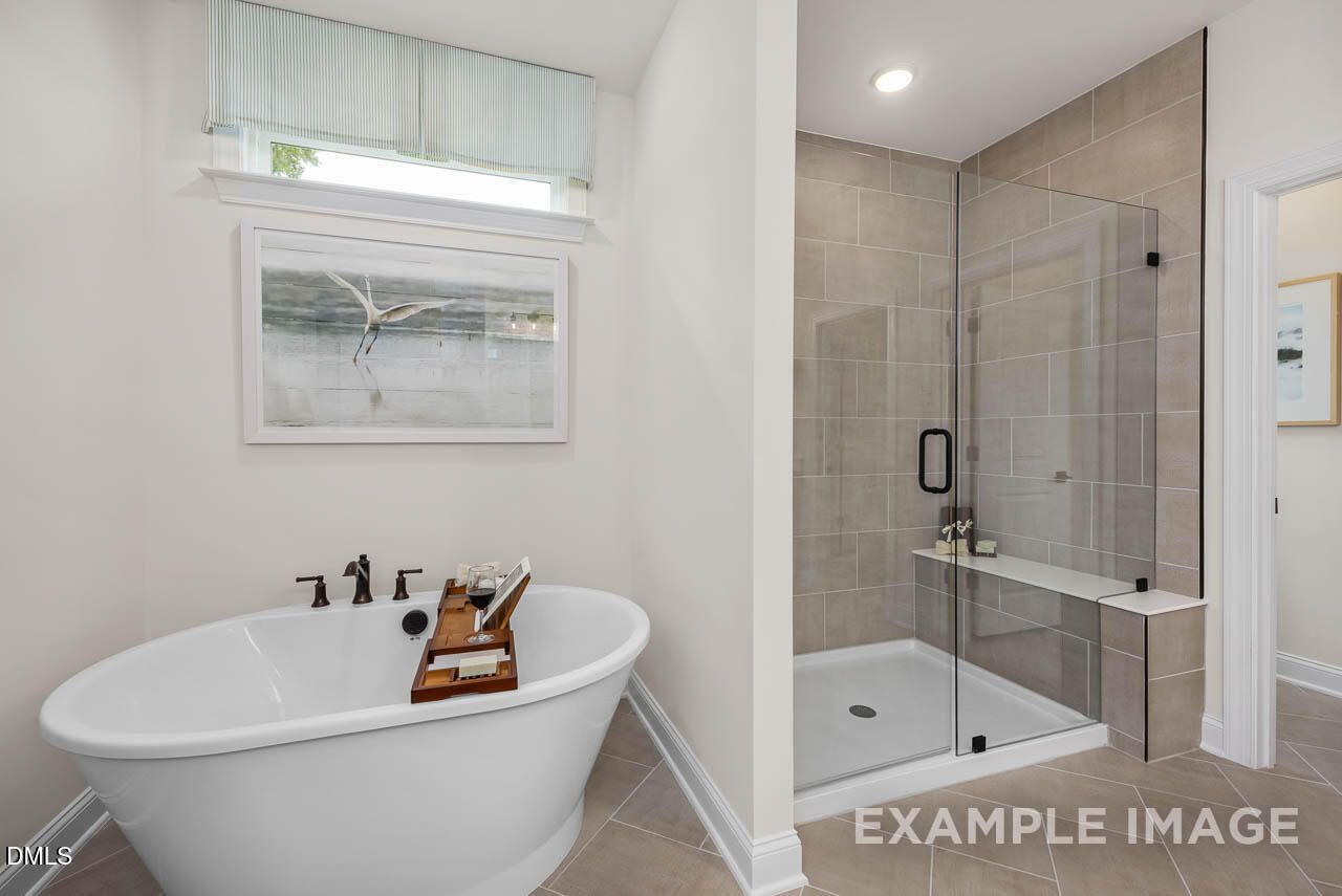 Elegant master bathroom featuring freestanding tub and glass walk-in shower in Davidson Homes The Crawford D, Raleigh