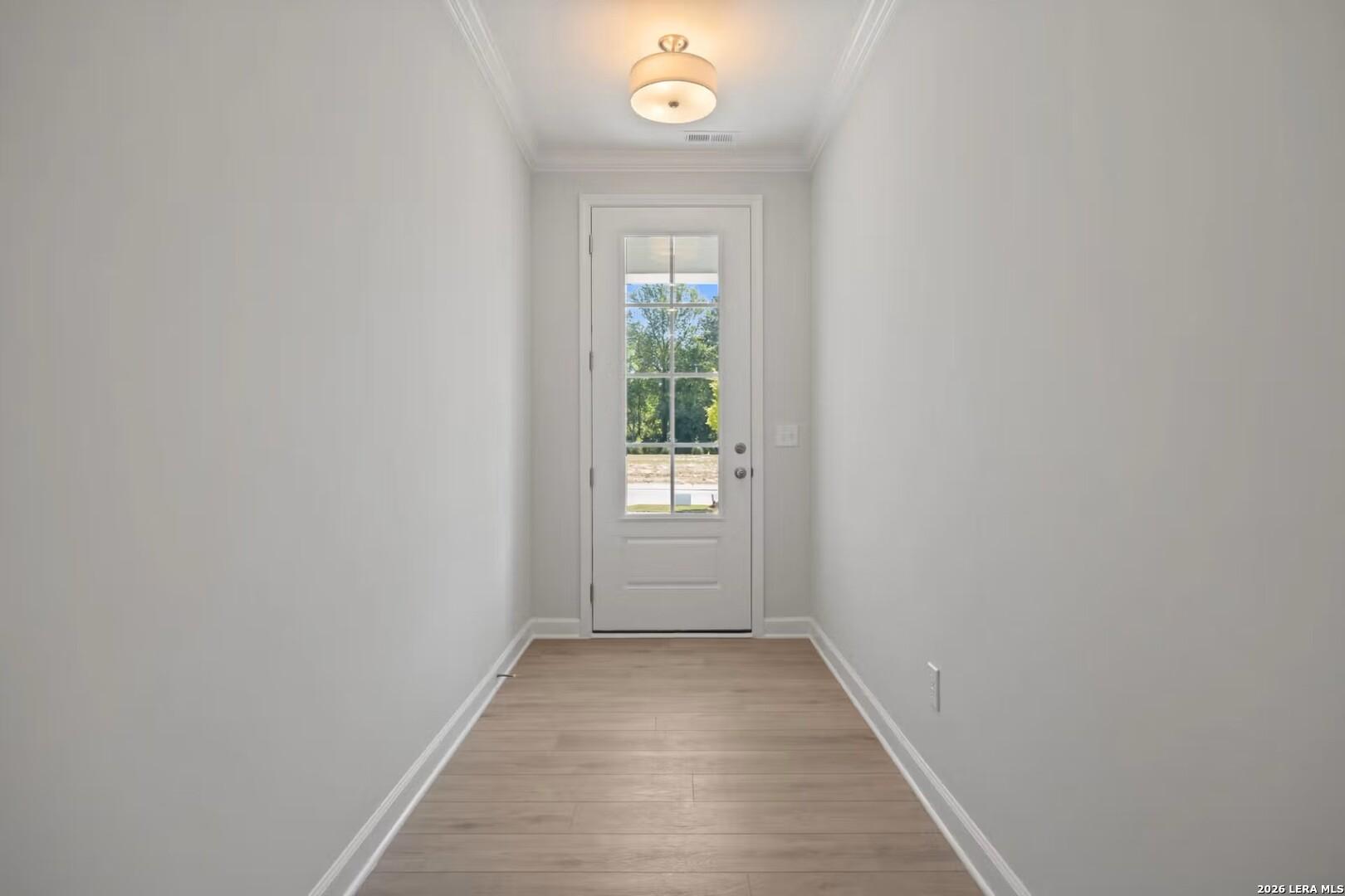 Bright entryway featuring light wood flooring and glass-paneled door in The Ashport F floor plan, Morgan Meadows, San Antonio