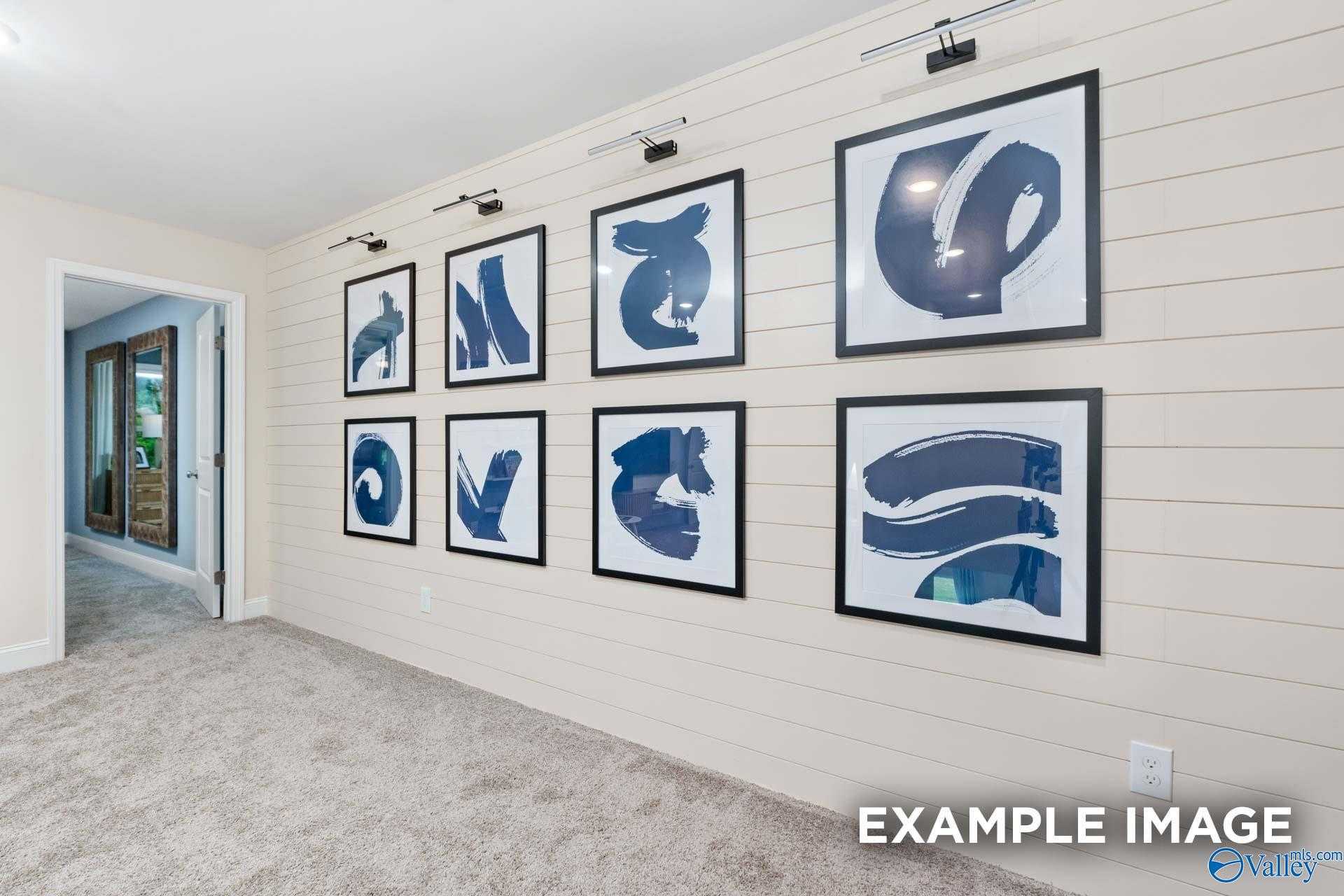 Elegant shiplap hallway with black-framed abstract blue artworks and recessed lighting in Davidson Homes The Camden B, Huntsville, Alabama