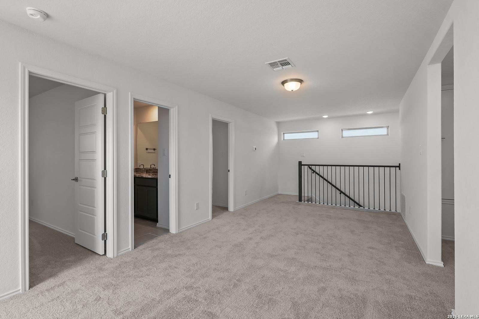 Spacious carpeted upstairs loft in The Brazos B floor plan by Davidson Homes in Agave, San Antonio, Texas.