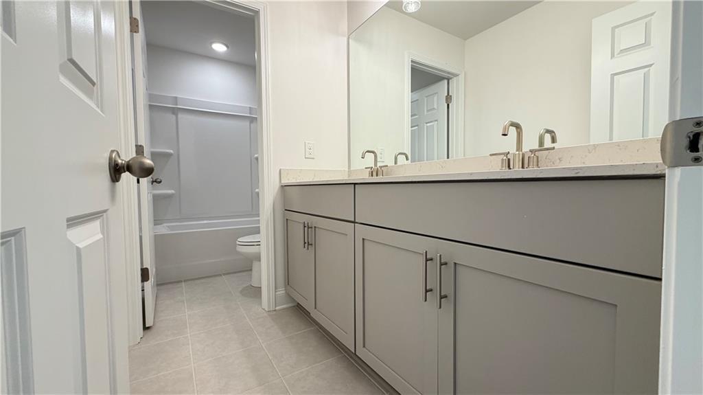 Modern bathroom with double vanity and shower-tub combo in The Hickory C floor plan by Davidson Homes in Hoschton, GA.