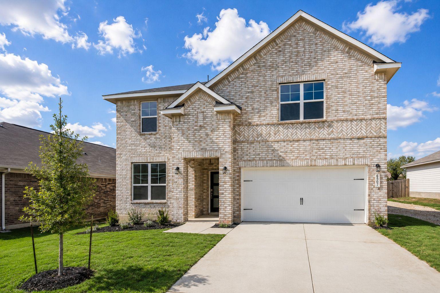 Two-story brick exterior of a Davidson Homes house at Morgan Meadows in San Antonio, Texas with a two-car garage.