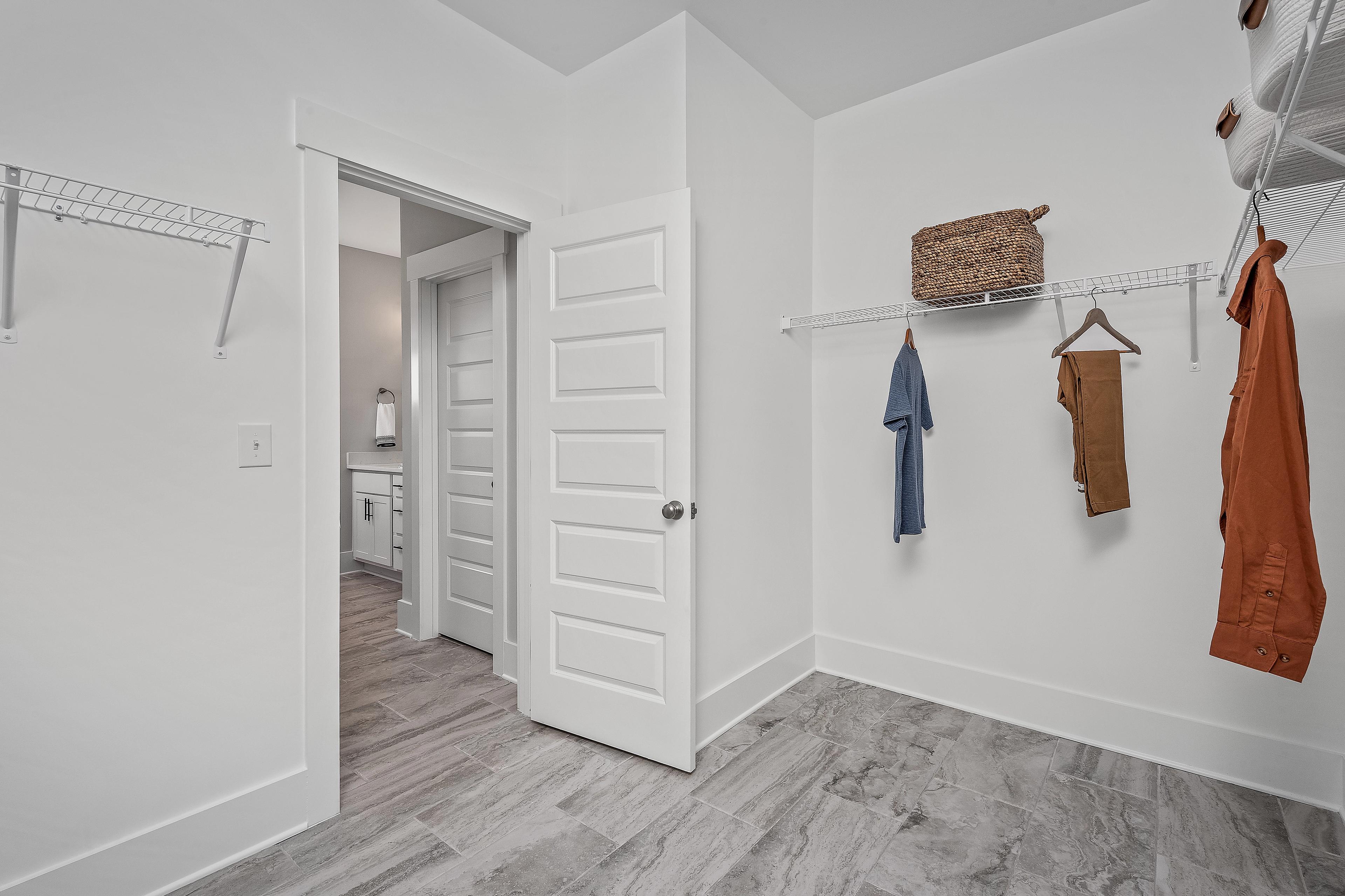 Spacious walk-in closet at Cain Park in Hartselle, Alabama by Davidson Homes with wire shelving, hanging storage and hardwood floors