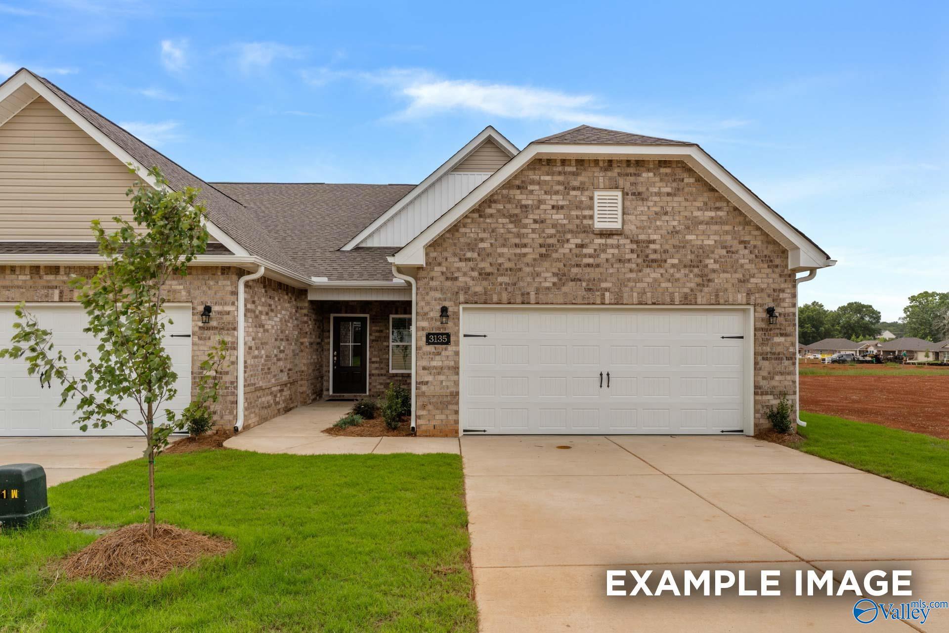 Brick single-story home with 2-car garage, shingled roof, driveway, and landscaped yard in The Retreat at Hollon Meadow, Decatur, Alabama