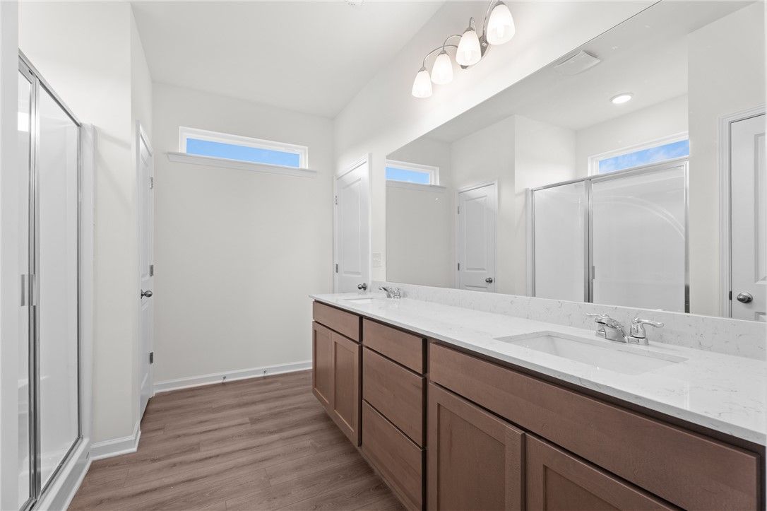 Modern bathroom with dual vanity and walk-in shower in The Stella D floor plan by Evermore Homes in Silver Oak, Cusseta.