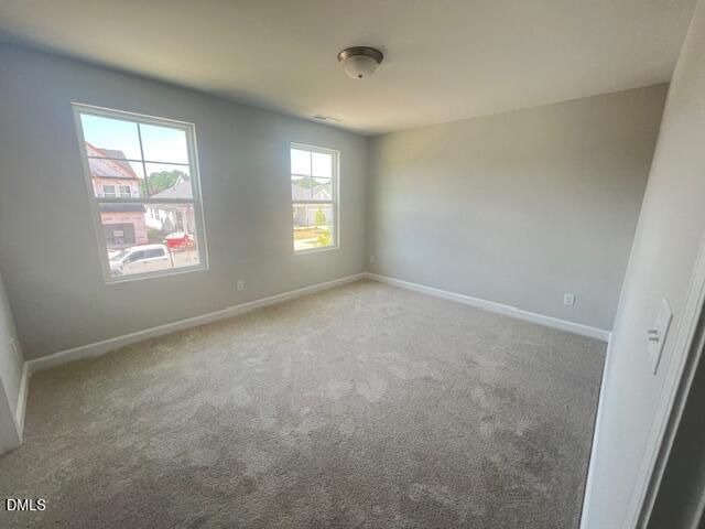 Bright secondary bedroom with large windows, gray walls, and carpet in Davidson Homes The Adalynn A, Lillington, NC