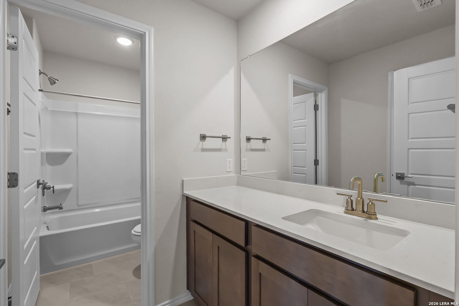 Modern bathroom with vanity and tub-shower combo in The San Marcos F floor plan by Davidson Homes in San Antonio, Texas.