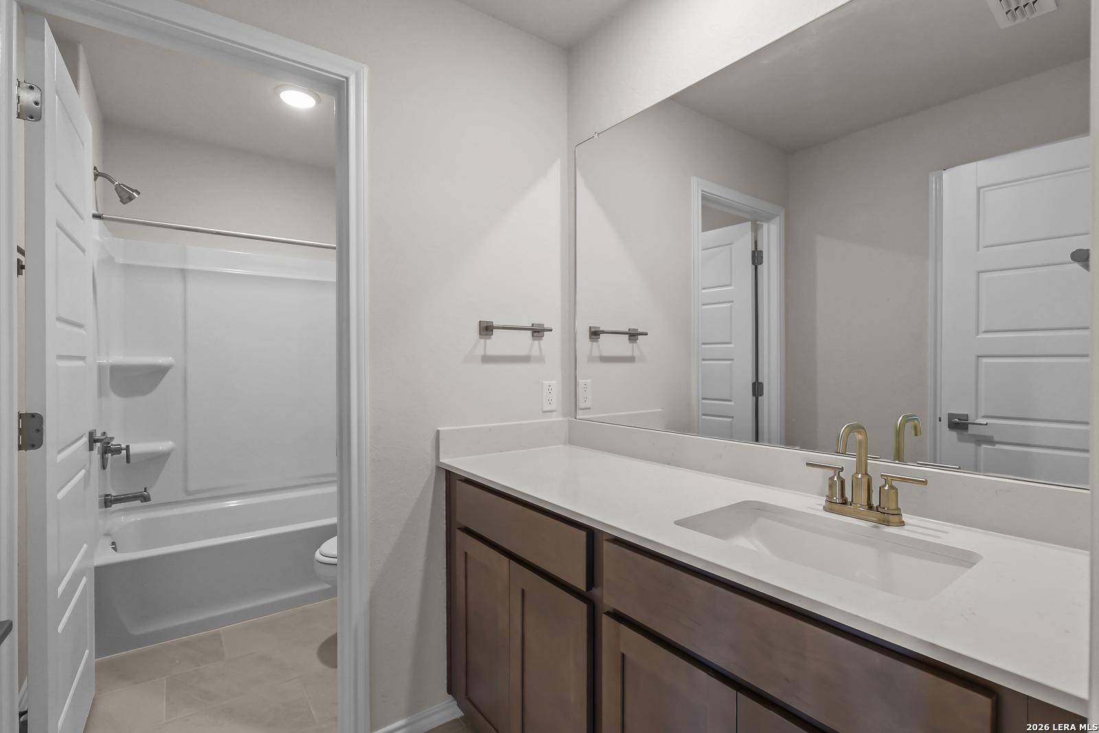 Modern bathroom with vanity and tub-shower combo in The San Marcos F floor plan by Davidson Homes in San Antonio, Texas.