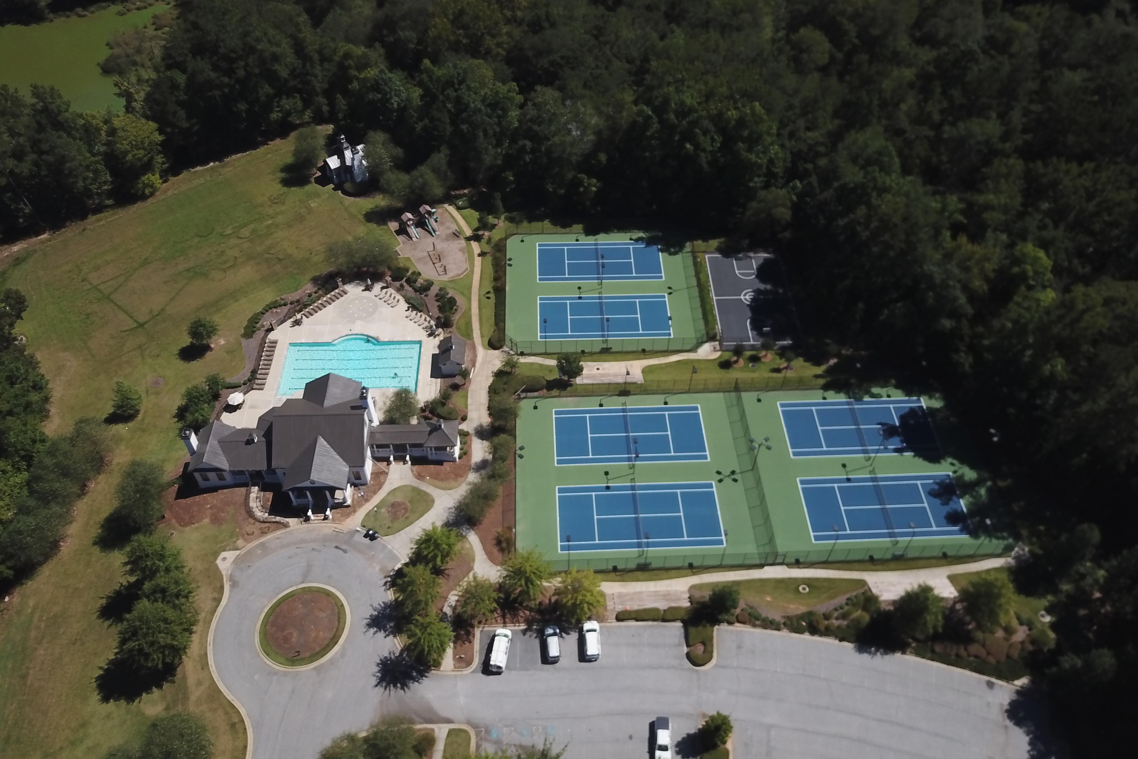 Aerial view of resort-style pool, multiple tennis courts and clubhouse at Riverwood in Dallas, Georgia