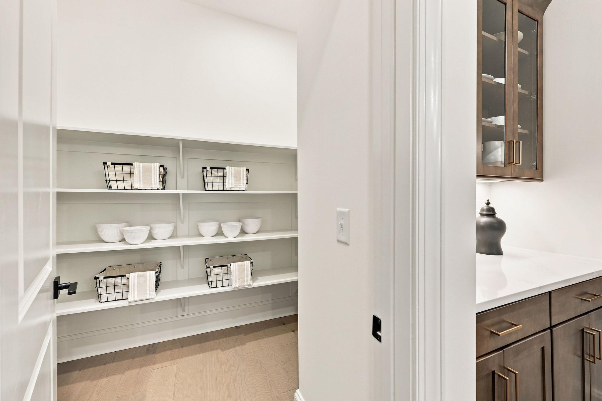 Walk-in pantry with organized shelving and adjacent butler’s pantry in The Barrington C home design by Davidson Homes.