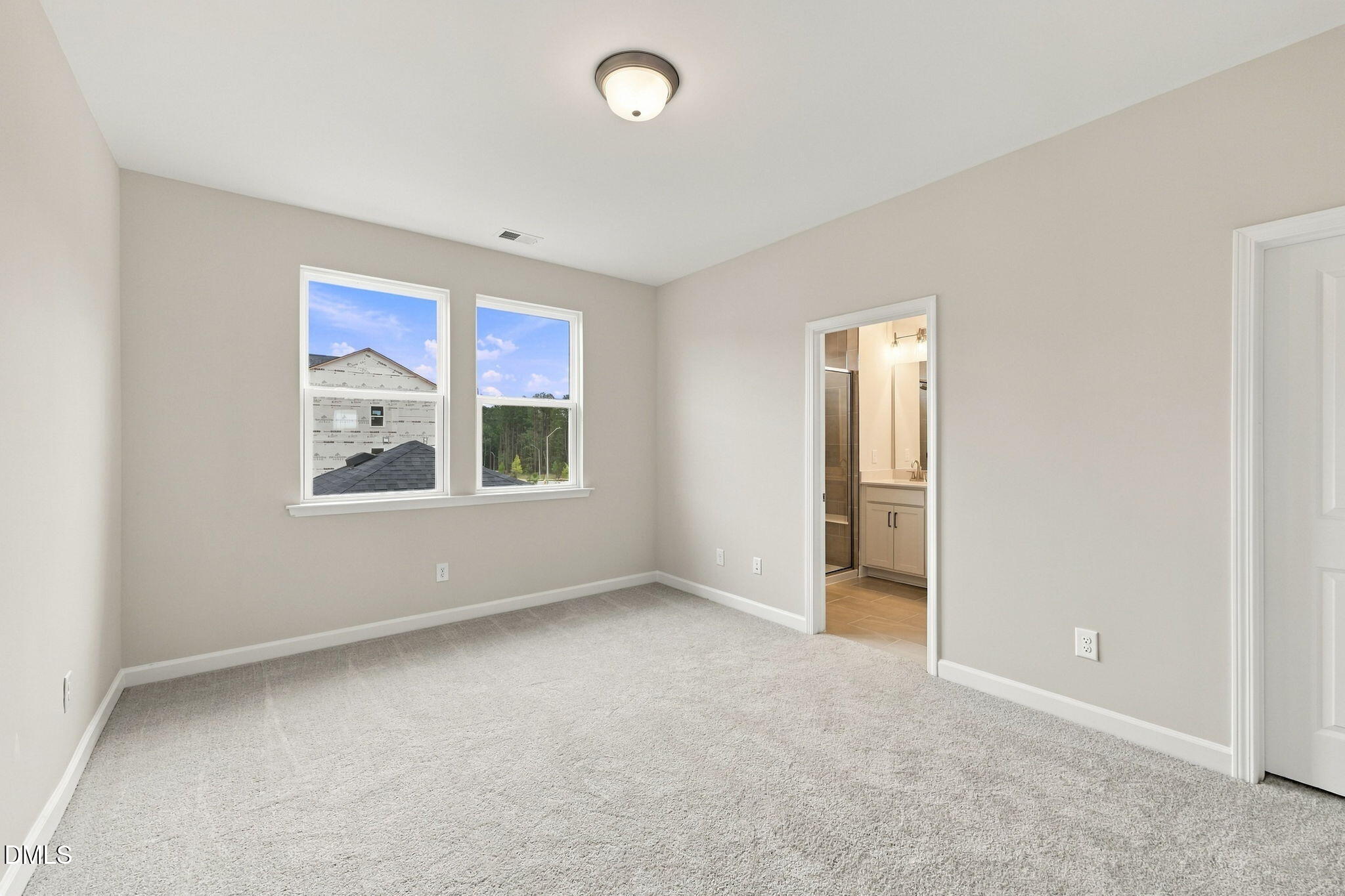 Bright carpeted bedroom with dual windows and en-suite bath in Davidson Homes' The Alexander B, Knightdale, North Carolina