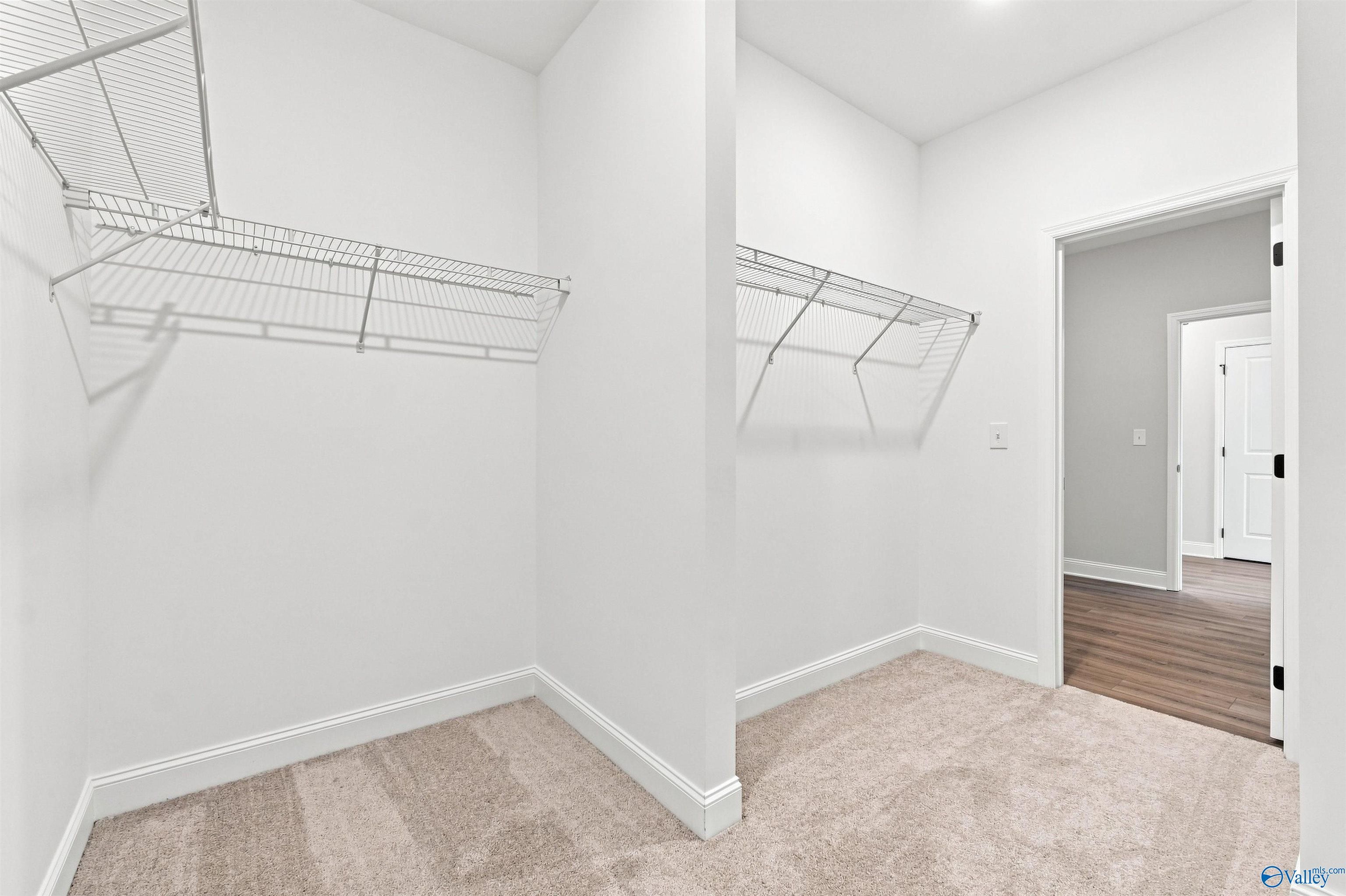 Spacious walk-in closet with wire shelving and carpet flooring in Davidson Homes The Everett B plan, Wood Trail, Toney, Alabama