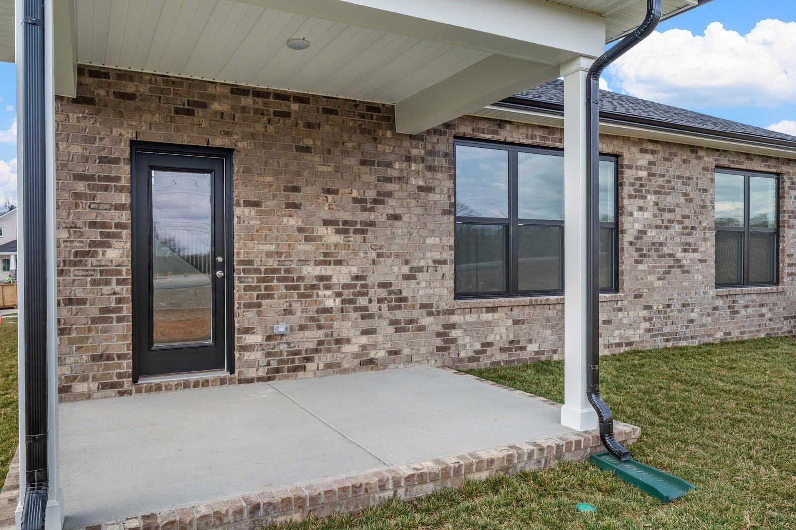 Covered concrete patio with brick exterior on The Ridgeport D floor plan in Benders Cove, Mt. Juliet, Tennessee.