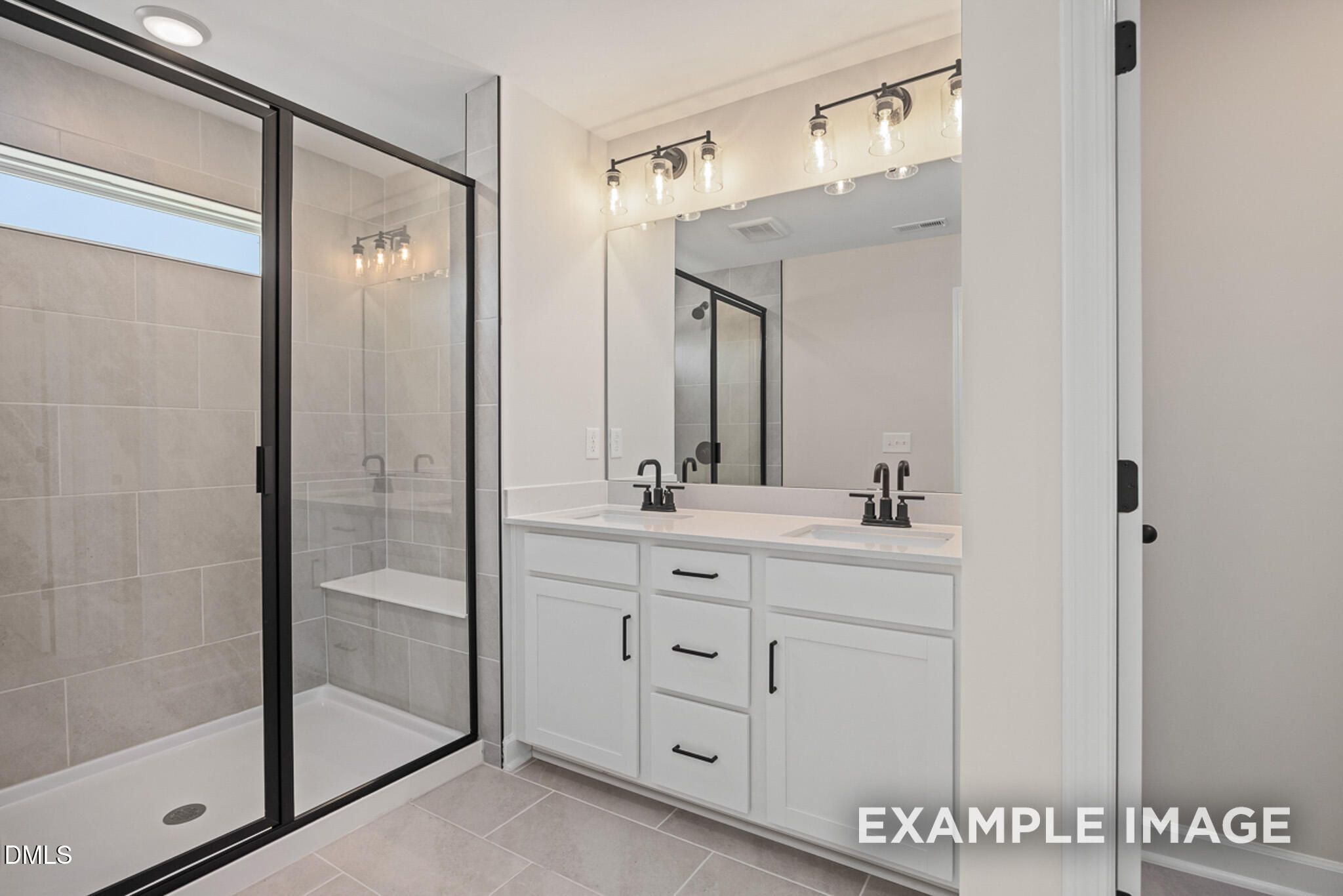 Modern bathroom with double vanity and glass-enclosed shower in The Mitchell floor plan at Camden Park, Knightdale, NC.