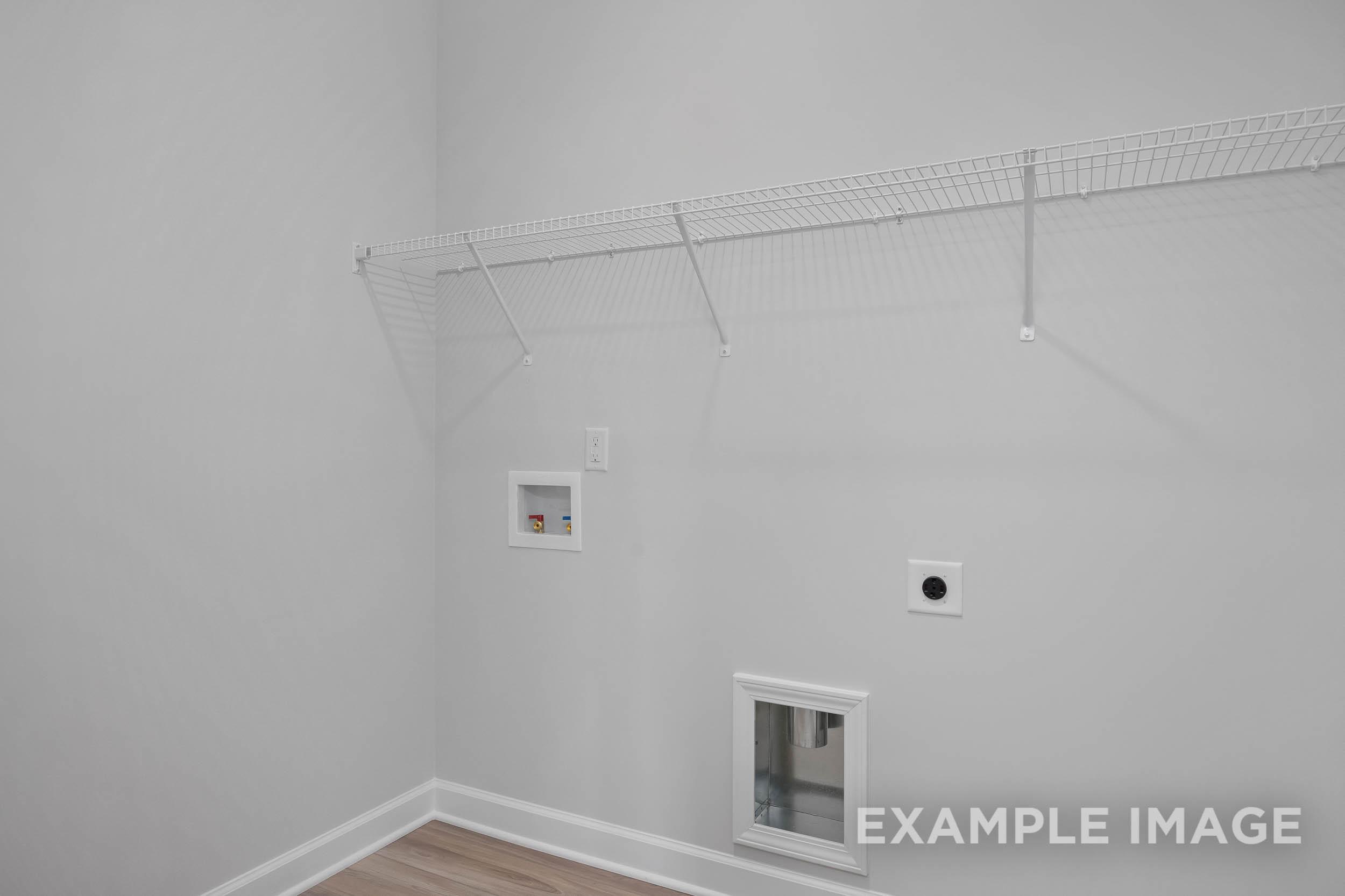 Laundry utility space in The Daphne C home design with wire shelving, outlets, and floor access panel