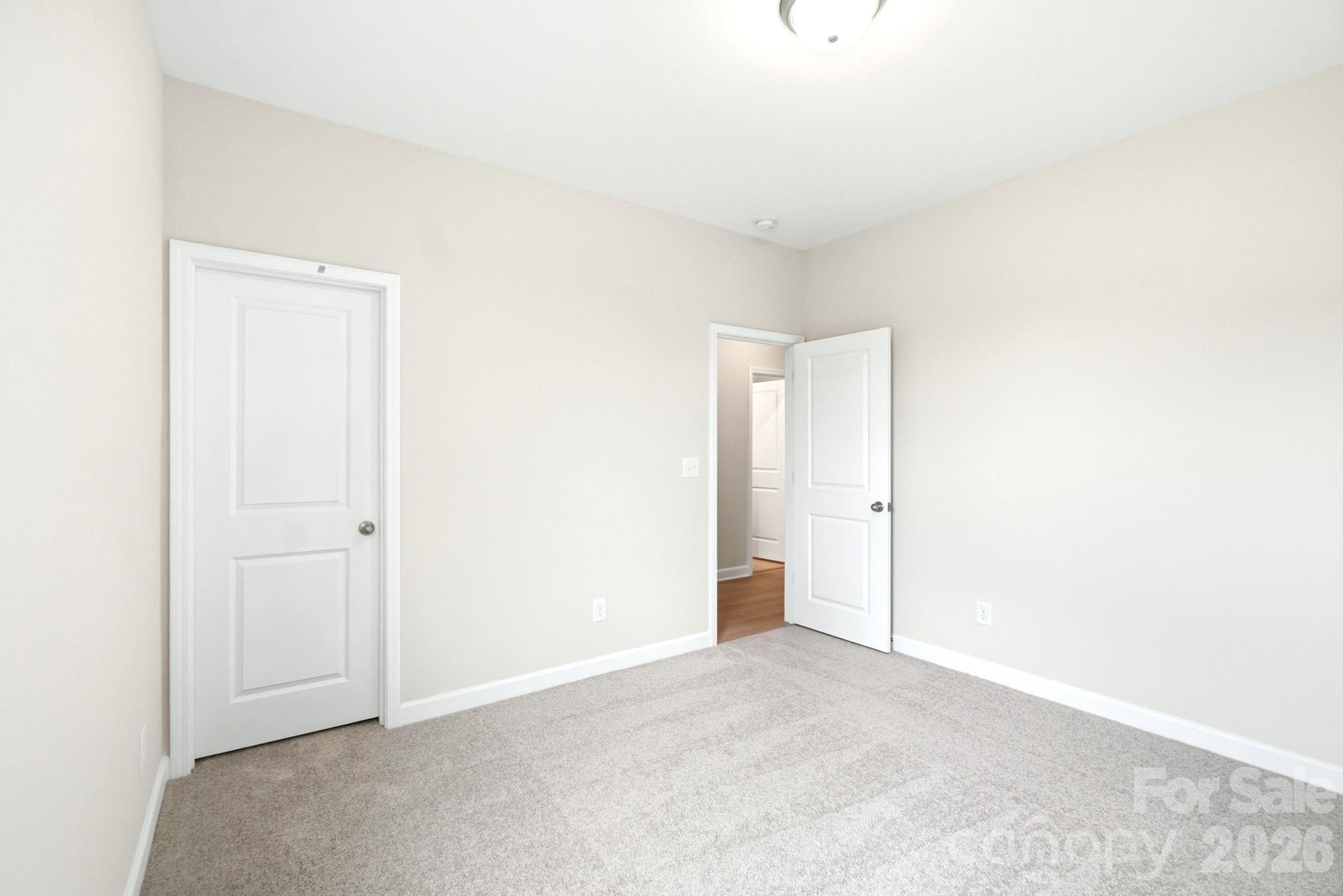 Spacious carpeted bedroom with neutral walls in The Magnolia B floor plan at Windgate in Mooresville, North Carolina.