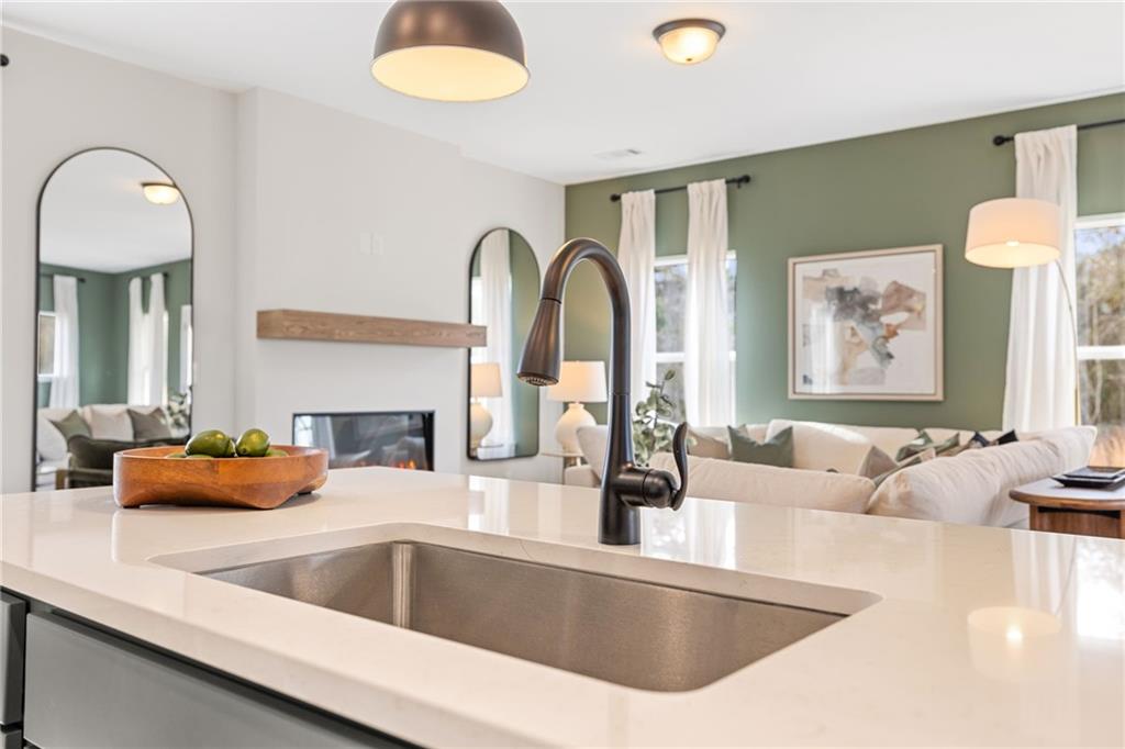 Modern kitchen island with quartz countertop overlooking open living room in The Rabun B floor plan, Canton, Georgia.