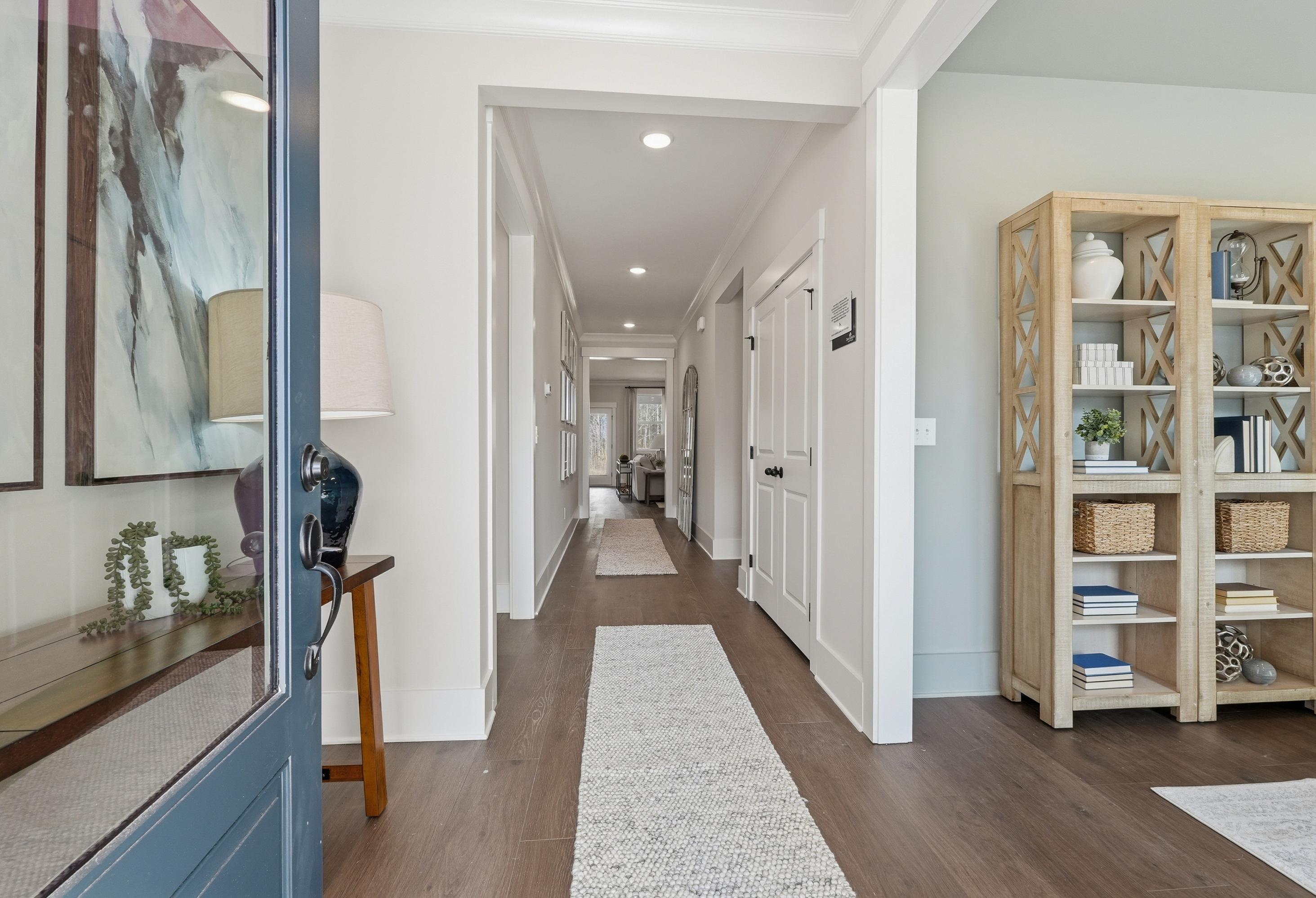 Bright, open entryway and hallway of The Hibiscus floor plan by Davidson Homes featuring modern decor and wood flooring.