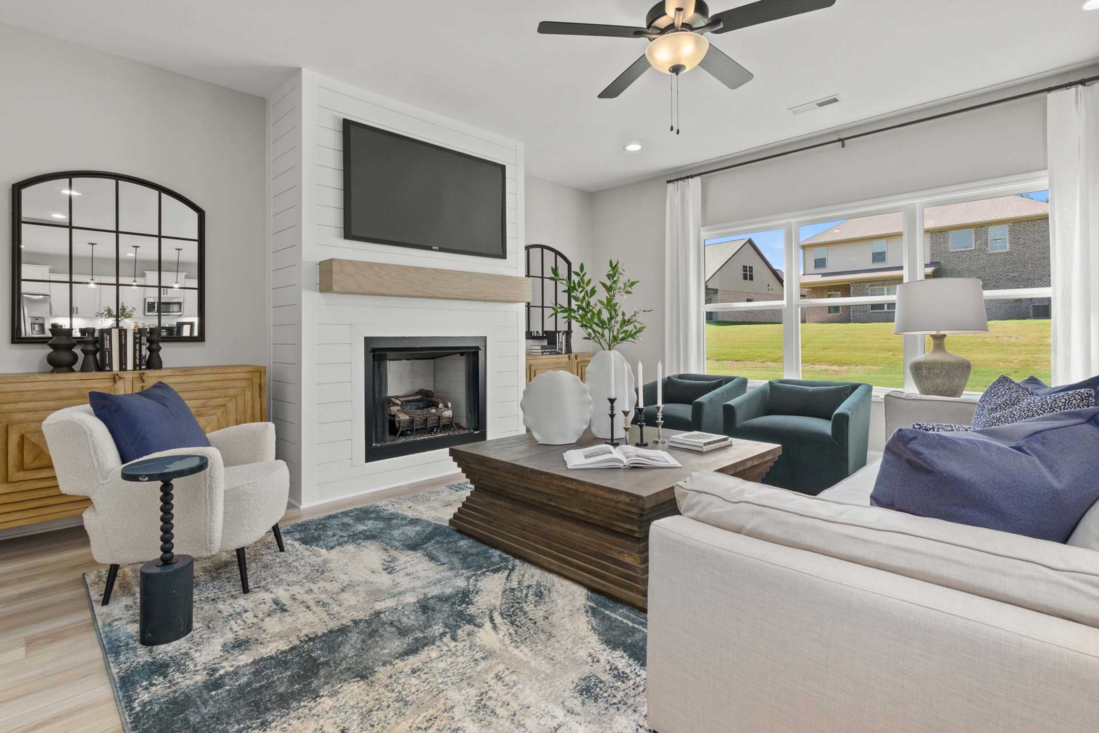Spacious living room in Creek Grove New Market AL with shiplap walls gas fireplace plush seating and scenic window views