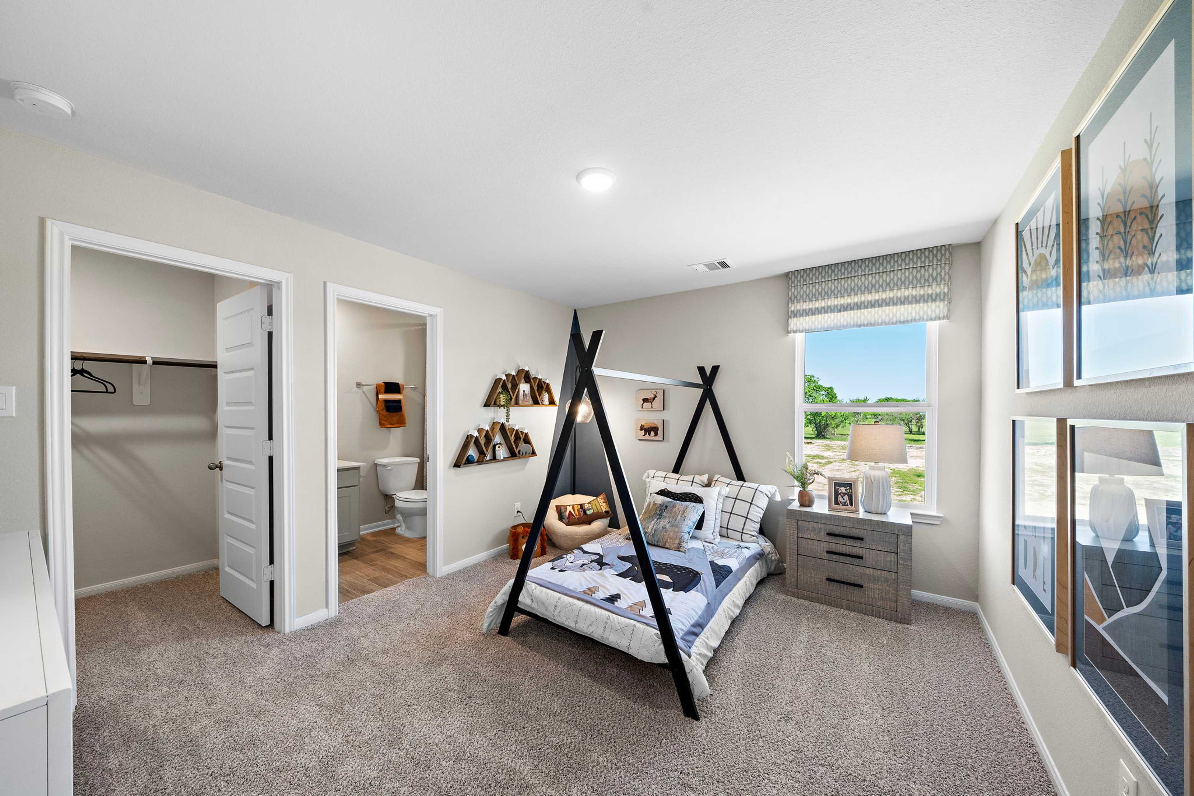Modern boy's bedroom at Emberly in Beasley Texas with teepee bed frame, decorative art, and window view