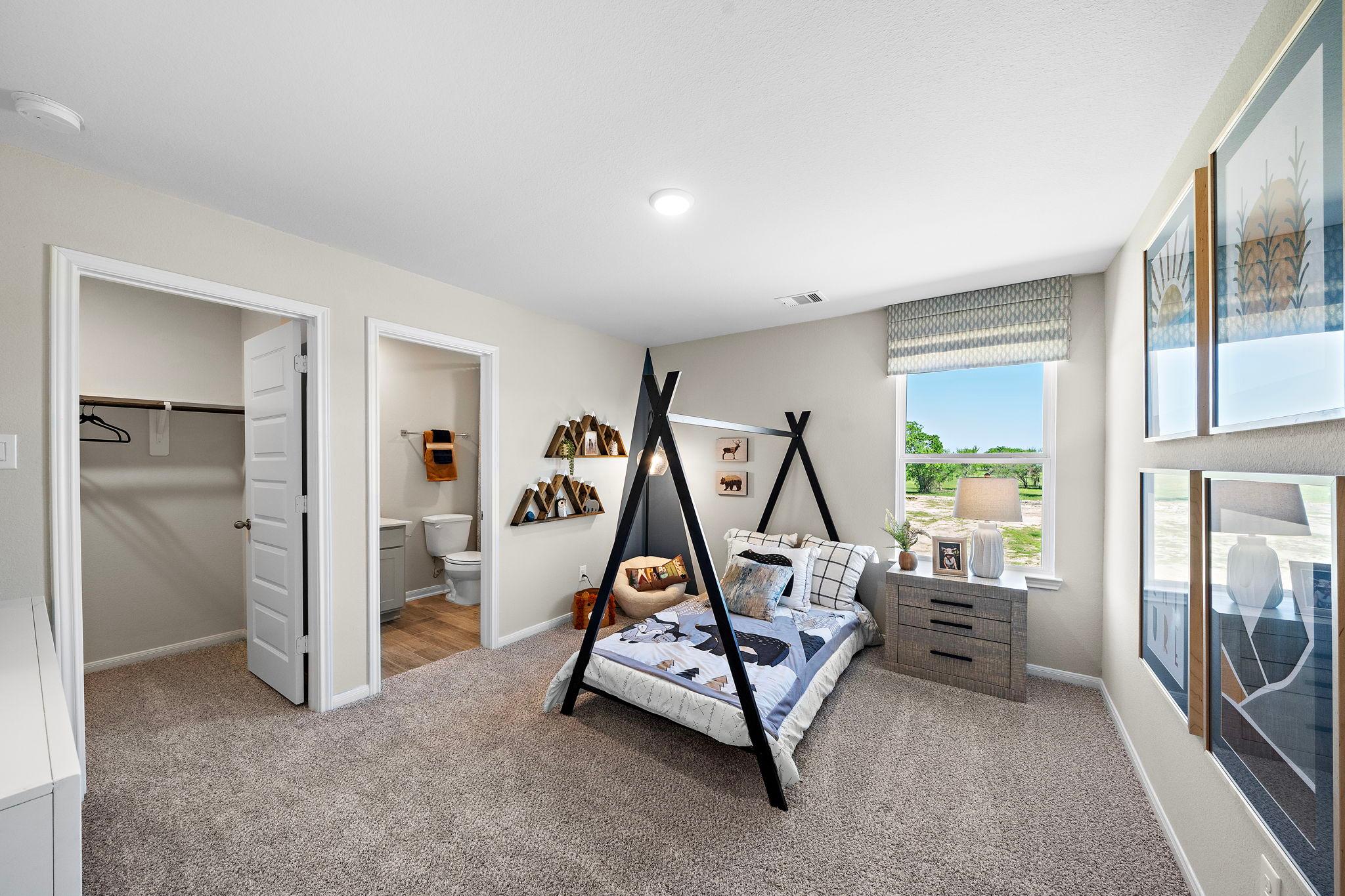 Modern boy's bedroom at Emberly in Beasley Texas with teepee bed frame, decorative art, and window view