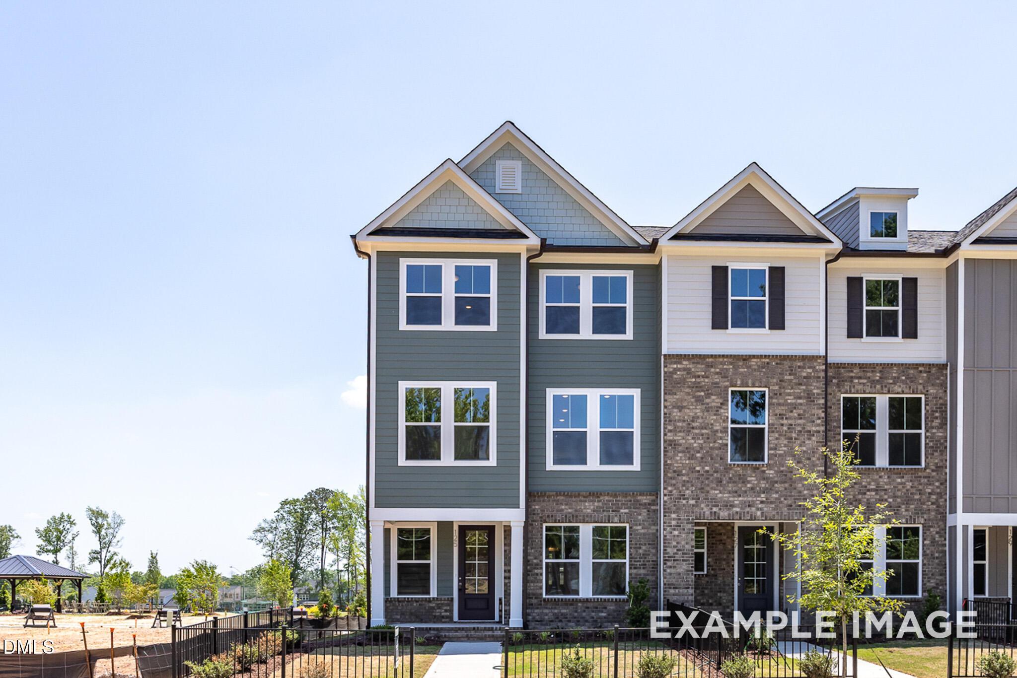 The Mitchell exterior 3-story townhome by Davidson Homes with brick and siding facade in Camden Park, Knightdale, NC.