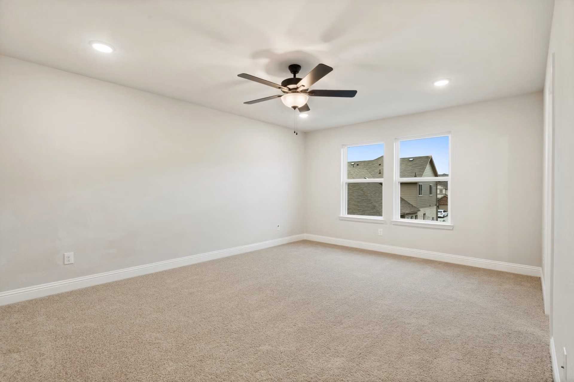 Spacious secondary bedroom with beige carpet, ceiling fan, and double windows in Davidson Homes The Wake D, Wylie, Texas