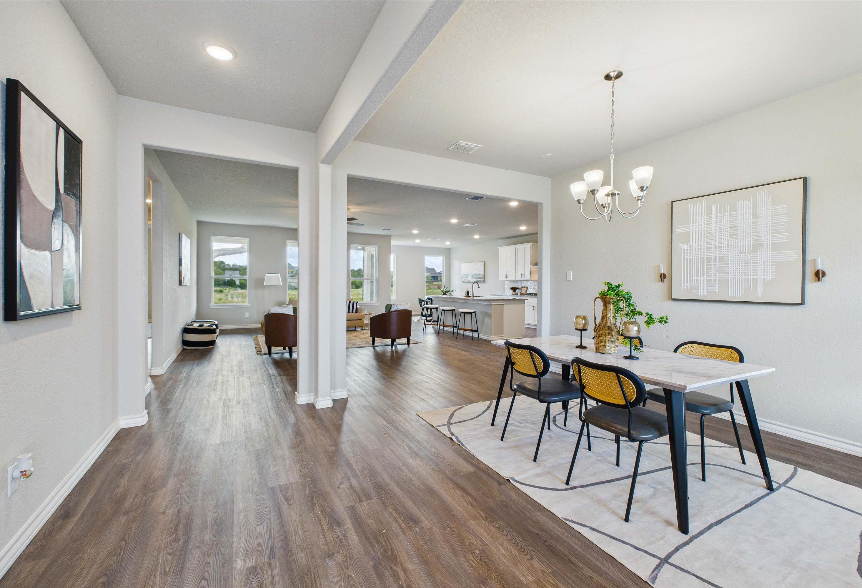 Open-concept dining and living area in The Foster E by Davidson Homes featuring modern finishes and wood-style flooring.