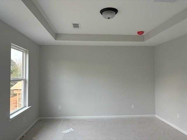 Spacious empty bedroom with gray walls, large window, ceiling light in Davidson Homes The Rabun C, Winder, Georgia