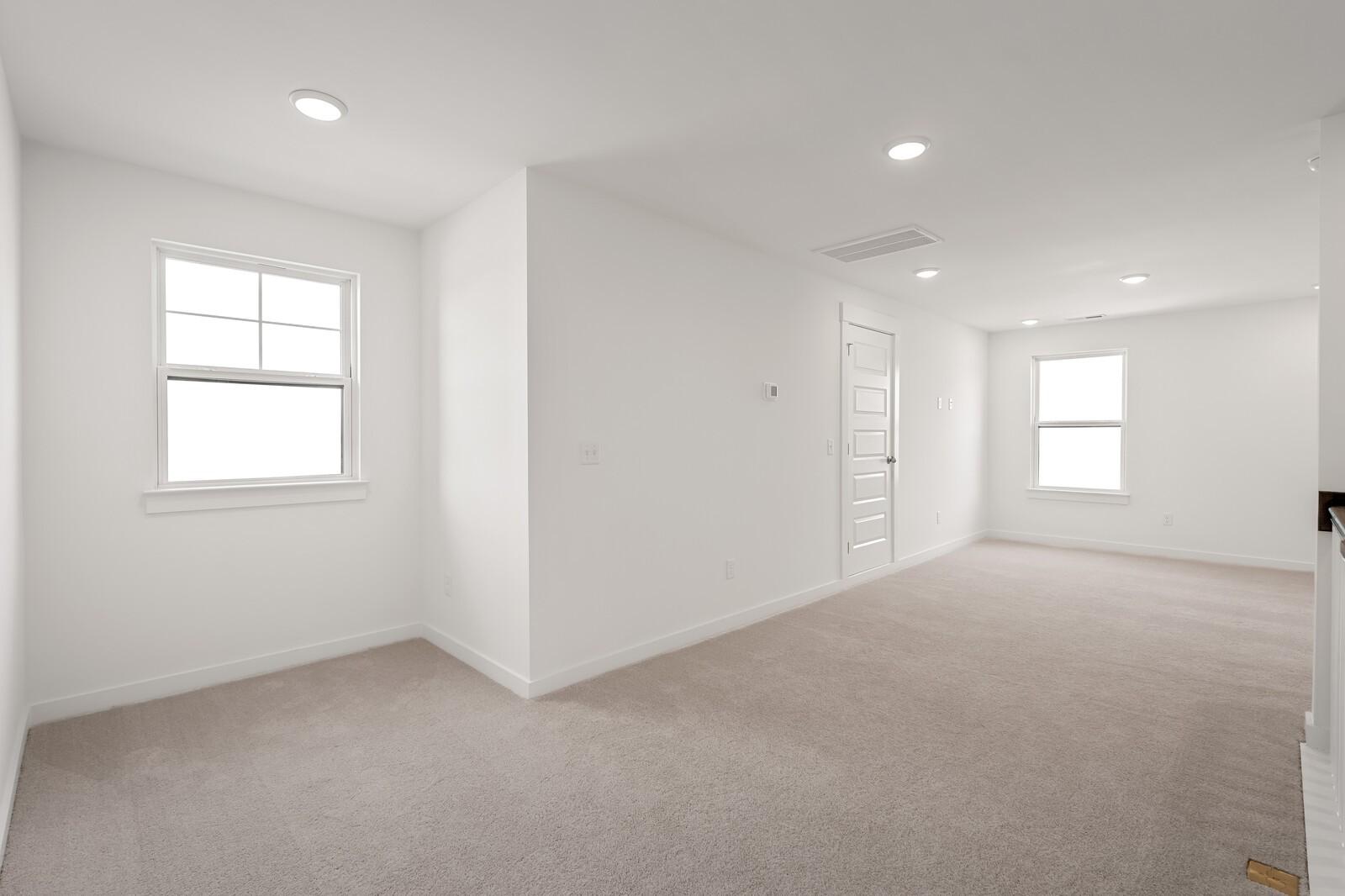 Bright upstairs bonus room with carpeted floors, white walls, large windows, and recessed lights in Davidson Homes The Ash C, Mt. Juliet, TN