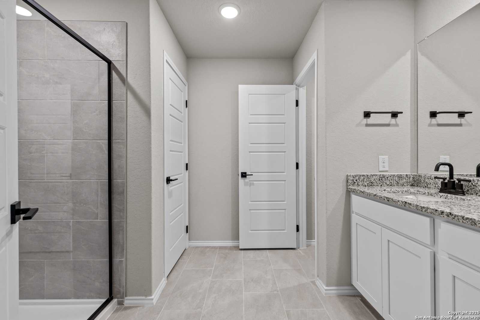 Modern master bathroom featuring frameless glass shower, quartz vanity, and subway tile in Davidson Homes The Murray I, San Antonio