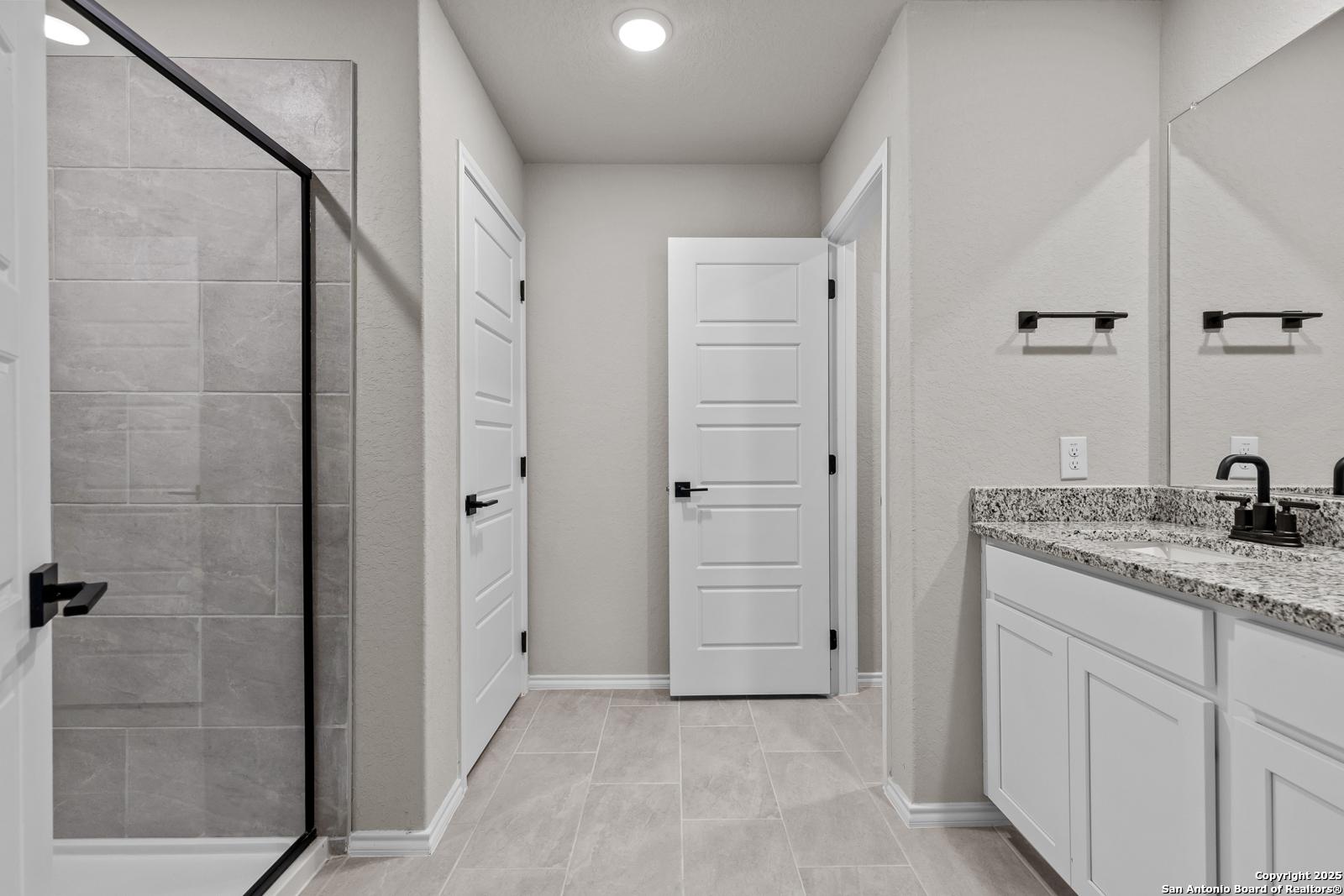 Modern master bathroom featuring frameless glass shower, quartz vanity, and subway tile in Davidson Homes The Murray I, San Antonio
