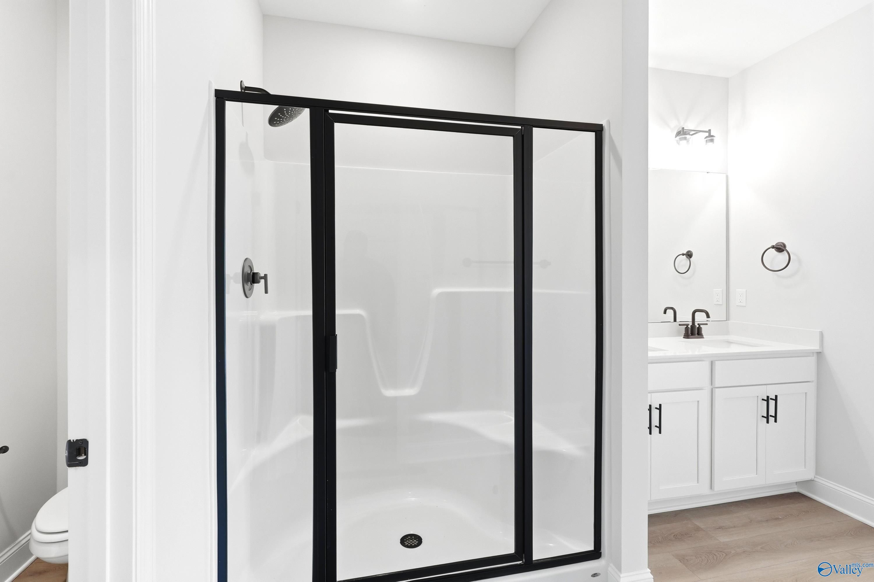 Modern bathroom with glass-enclosed shower and white vanity in The Daphne C floor plan at Flint Meadows, New Market, AL.