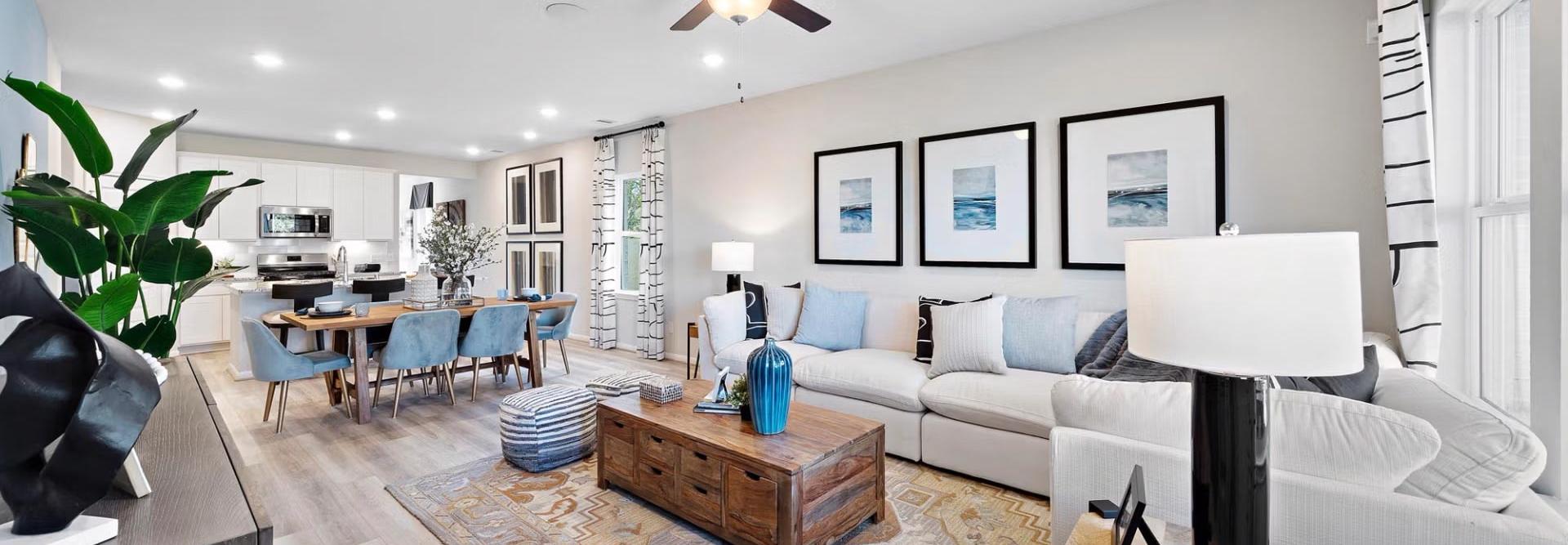 Spacious open-concept living room and kitchen at Saddle Creek Ranch in Cibolo Texas with hardwood floors ceiling fans and modern decor