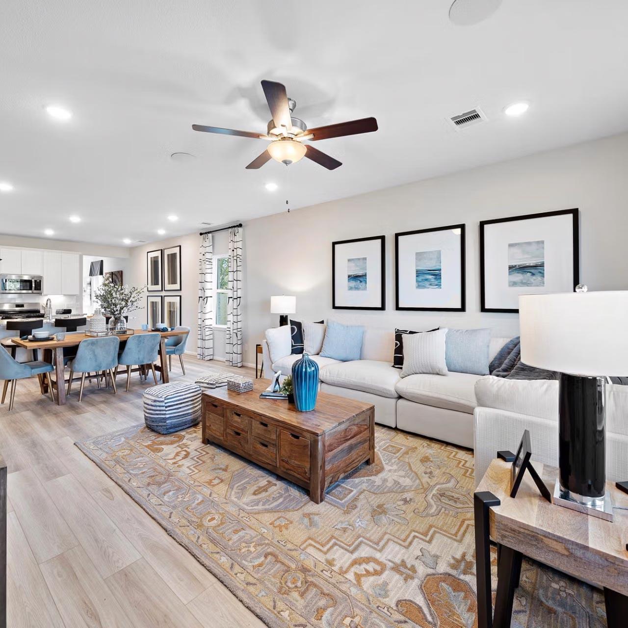 Spacious open-concept living room and kitchen at Saddle Creek Ranch in Cibolo Texas with hardwood floors ceiling fans and modern decor