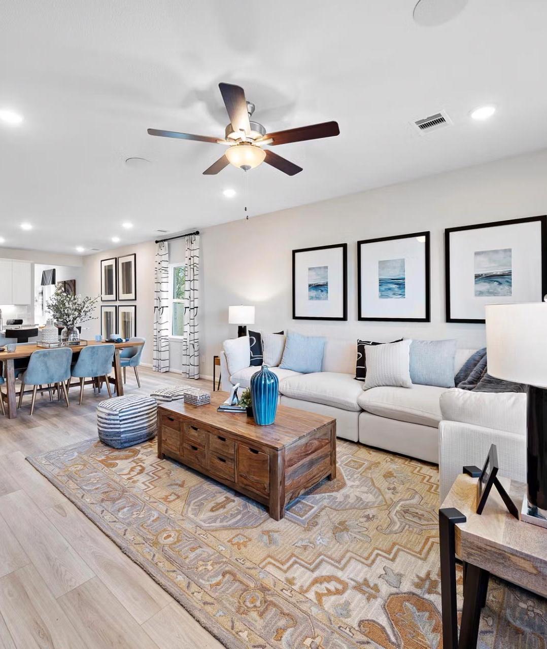 Spacious open-concept living room and kitchen at Saddle Creek Ranch in Cibolo Texas with hardwood floors ceiling fans and modern decor