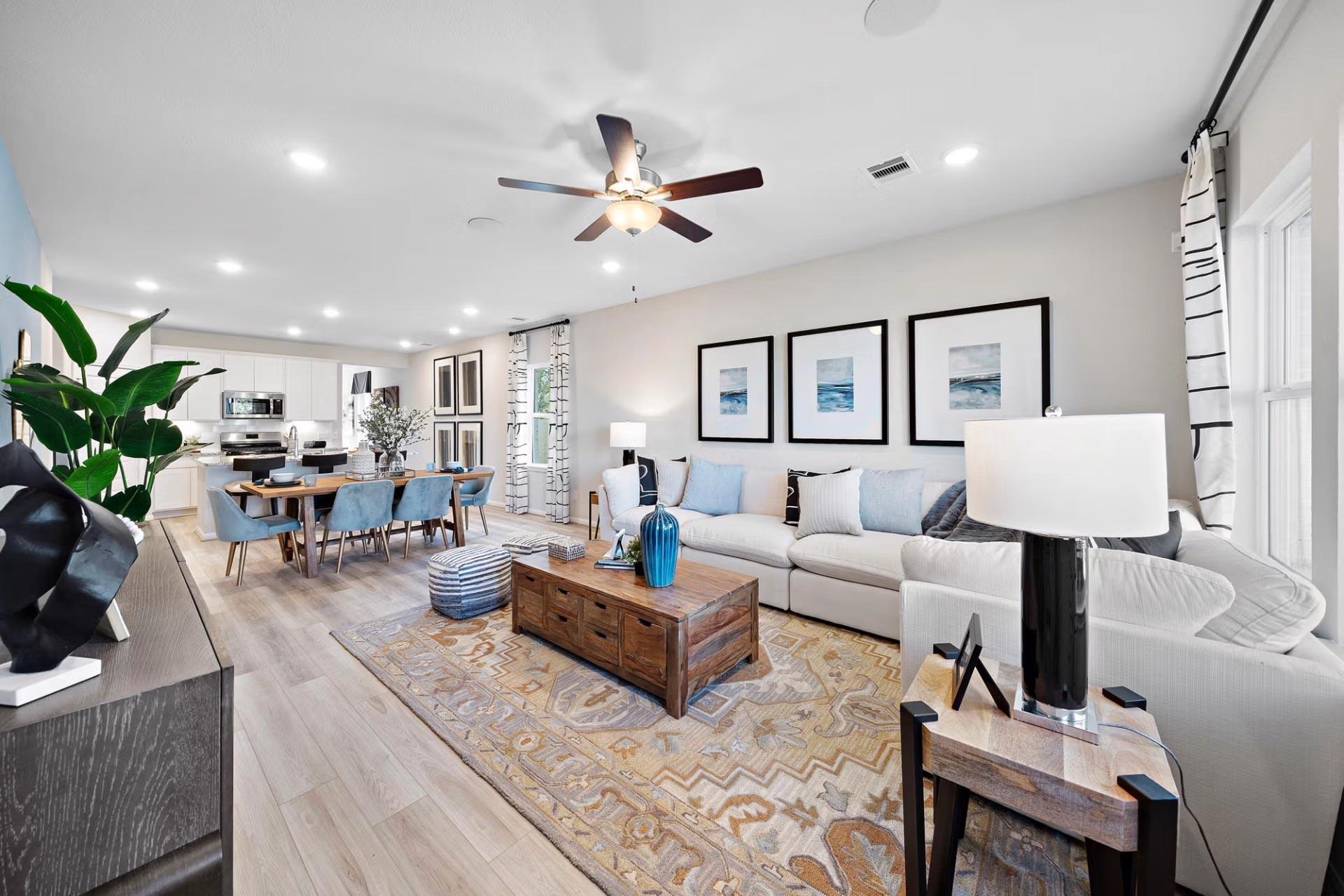 Open-concept living and dining room at Saddle Creek Ranch in Cibolo Texas with hardwood floors white sofa wooden coffee table and modern art