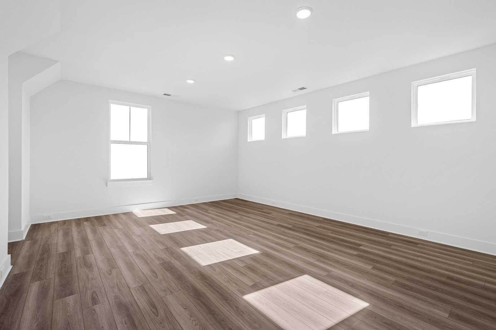 Bright upstairs bonus room with hardwood floors, large windows, and recessed lighting in Davidson Homes The Alston A, Murfreesboro