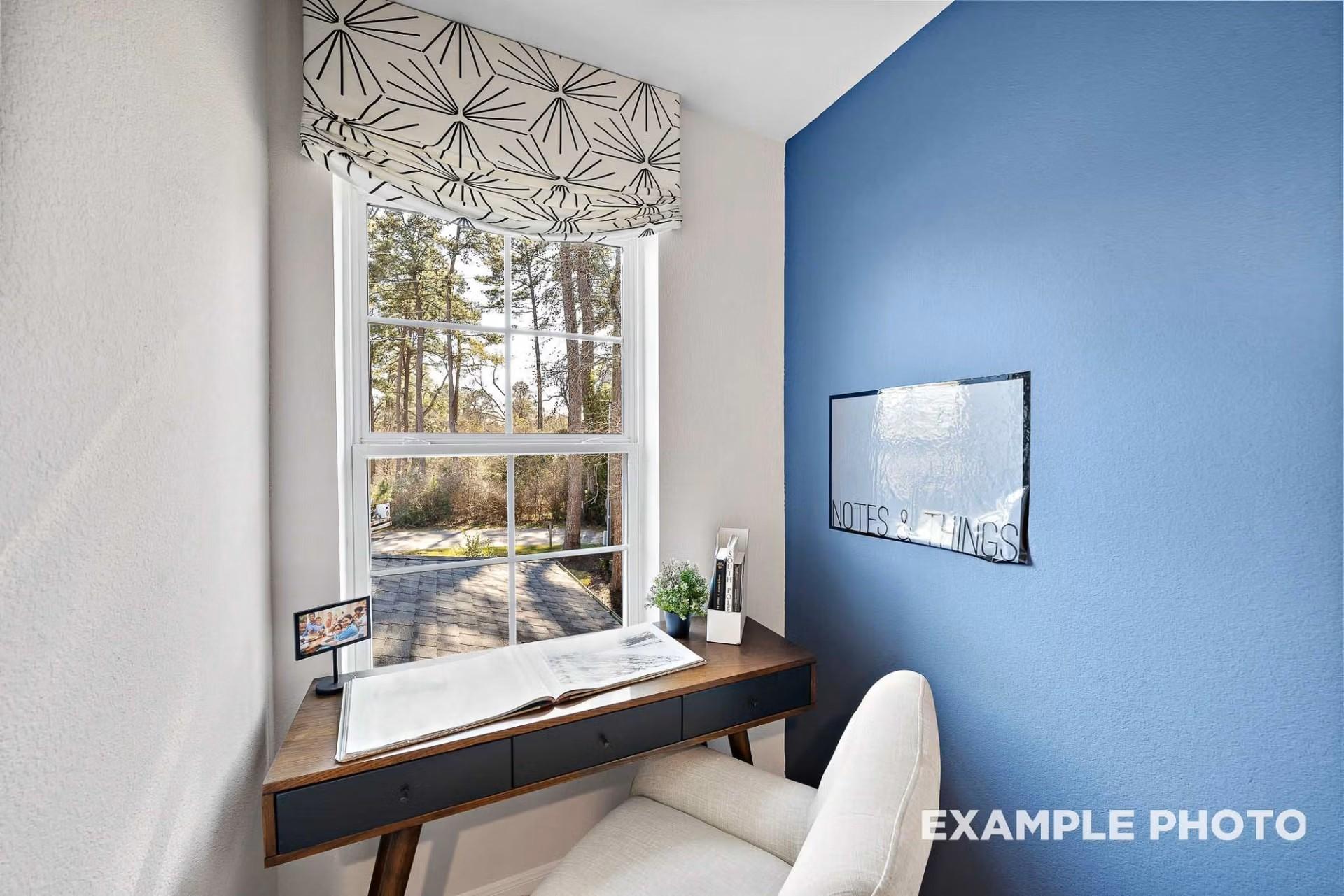 Cozy home office nook with blue accent wall and desk by window in The San Marcos E floor plan at Heartland, Texas.