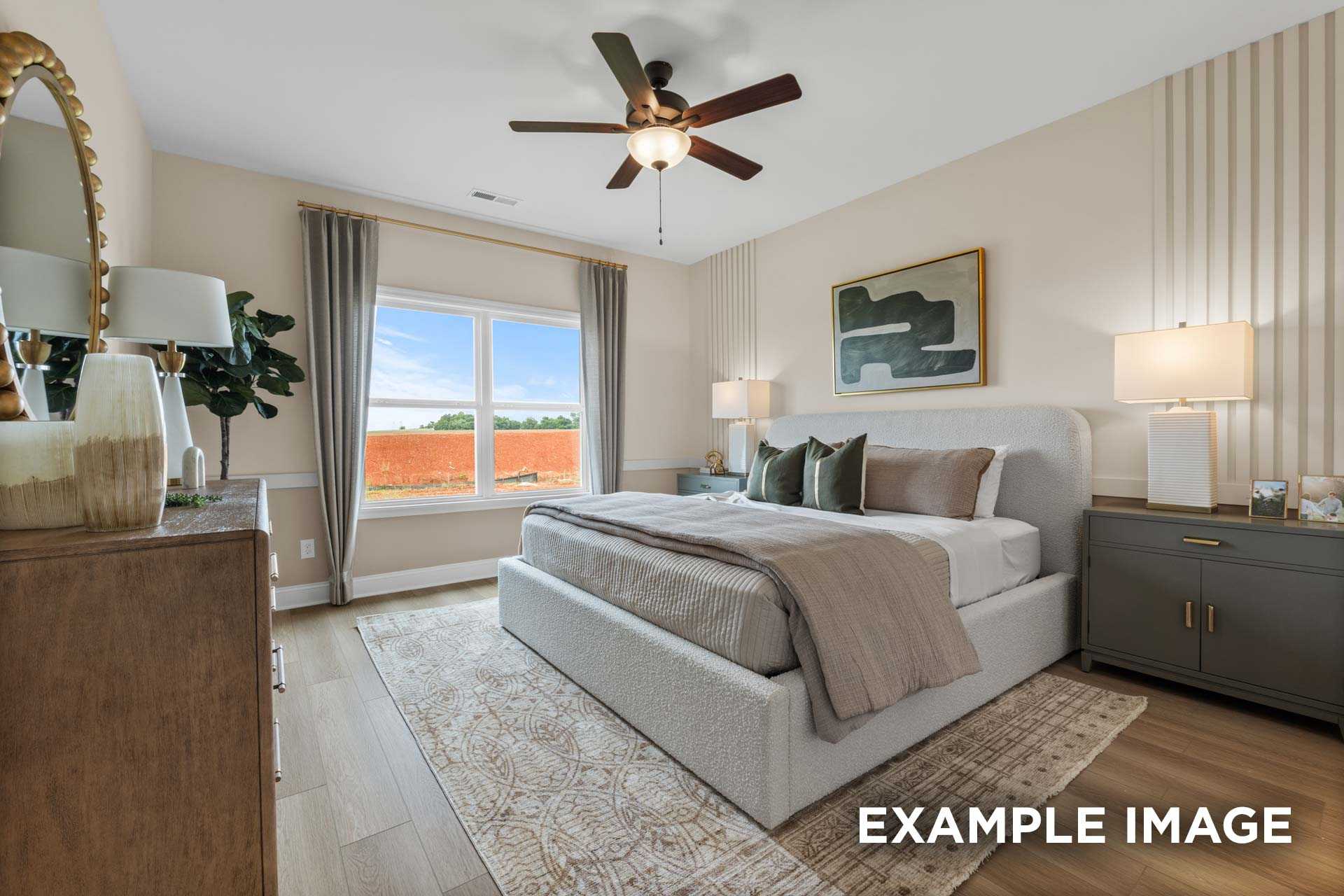 Serene master bedroom in The Laurel N with plush king bed, ceiling fan, lamps, and large window view