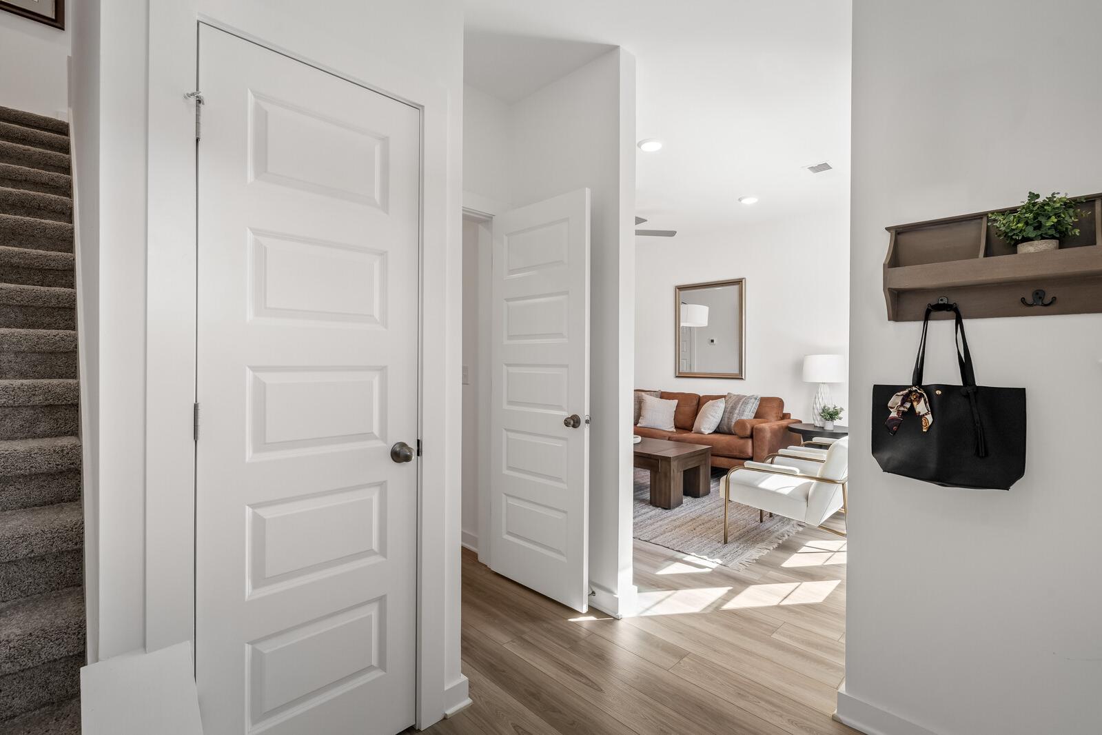 Spacious entryway opening to modern living room at The Towns at Red River in Gallatin TN with white doors, hardwood floors, leather sofa