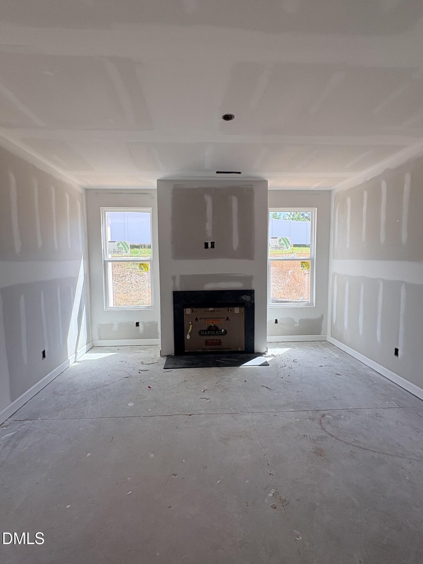 Unfinished living room with fireplace in The Ash C floor plan by Davidson Homes at Woodland Crossing, Zebulon, NC.