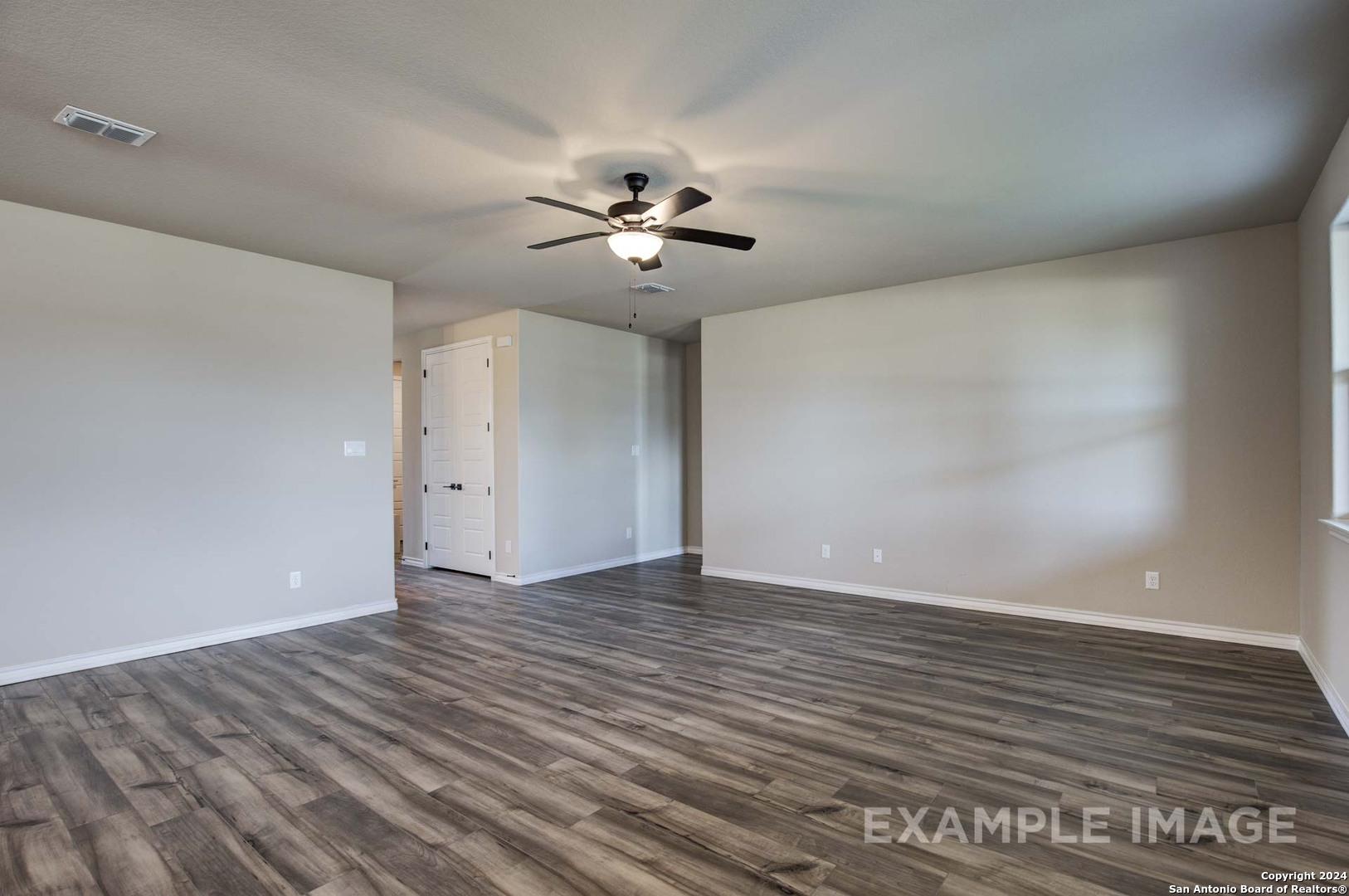 Spacious hallway with ceiling fan, neutral walls, and hardwood floors in Davidson Homes The Rockford G, Ladera, San Antonio