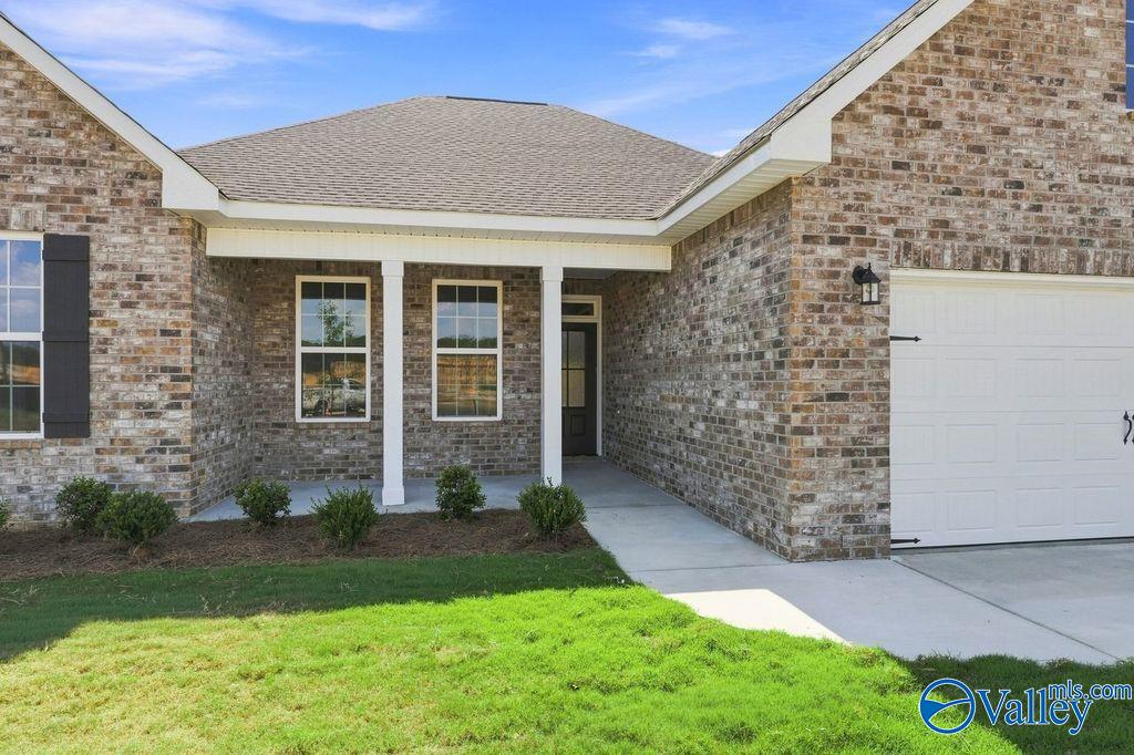 Brick exterior with covered front porch and 2-car garage at The Rockford by Davidson Homes in Cain Park, Hartselle, Alabama