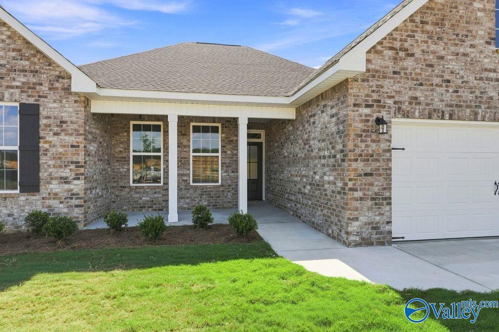 Brick exterior with covered front porch and 2-car garage at The Rockford by Davidson Homes in Cain Park, Hartselle, Alabama