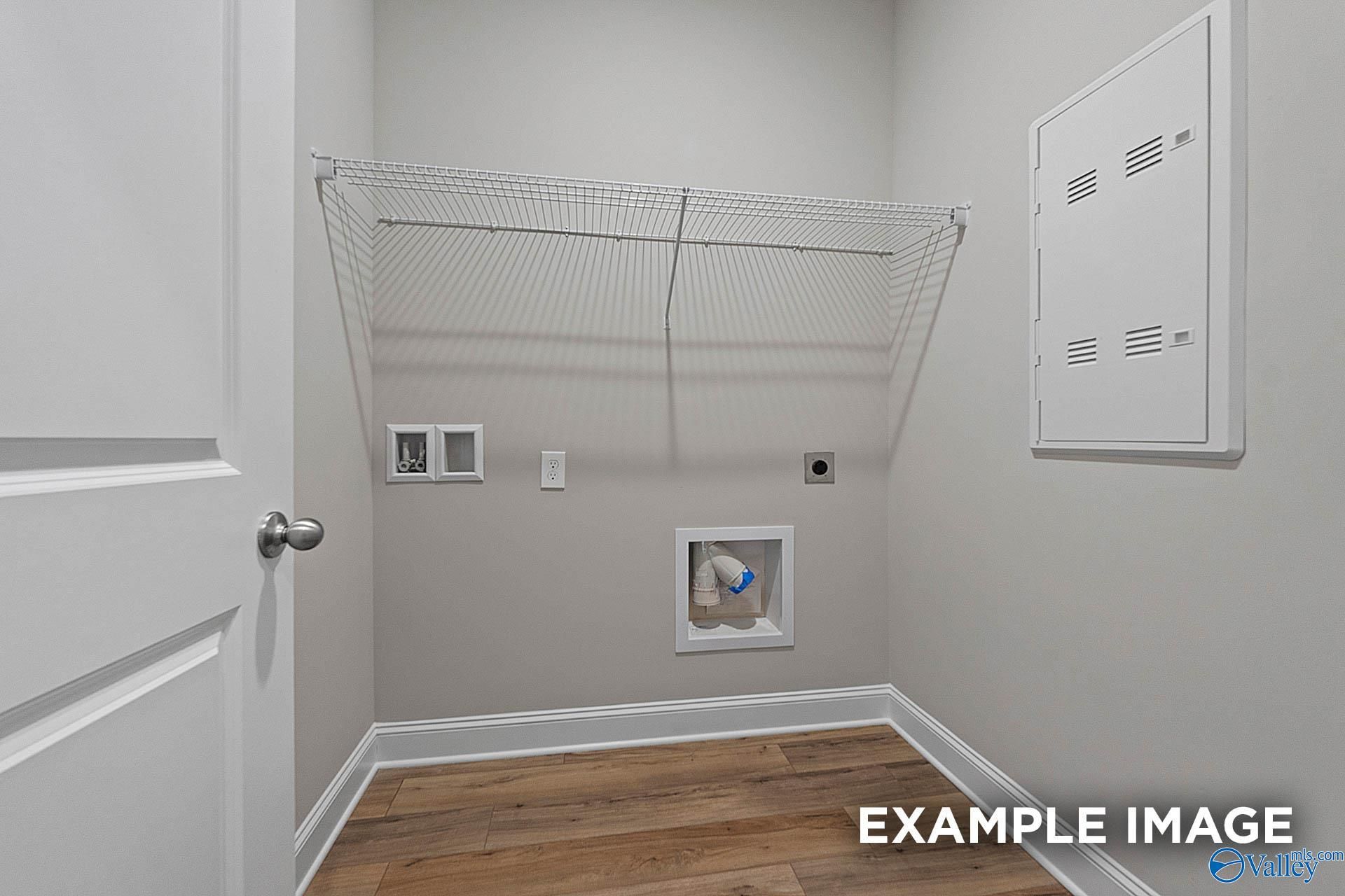 Functional laundry room with wire shelving, washer-dryer hookups, and hardwood floors in Davidson Homes The Franklin E, Hazel Green, Alabama